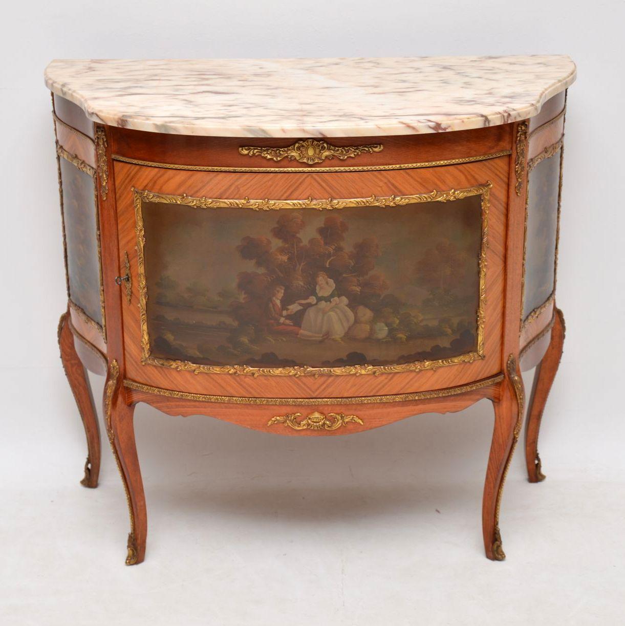 Antique French marble top cabinet with gilt bronze mounts and decorative scenes in panels. It’s in very good condition and I would date circa 1930s period. The marble top is original and can be lifted off the cabinet separately. There is one