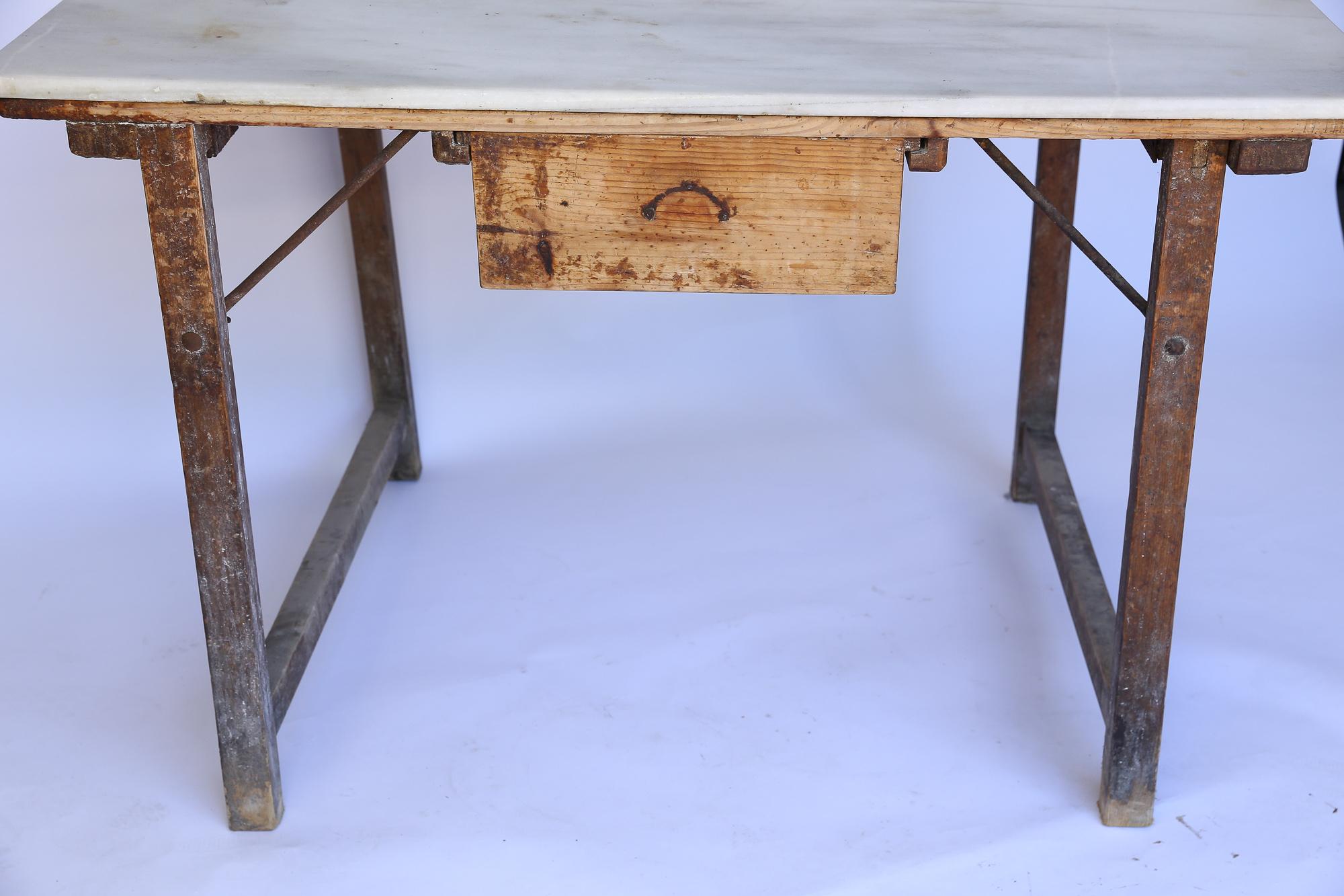 This is a wonderful antique French work table with a marble top and one drawer. The rustic patina and sturdy construction make the piece a great option as a kitchen island. The drawer measurements are as follows: 15.25
