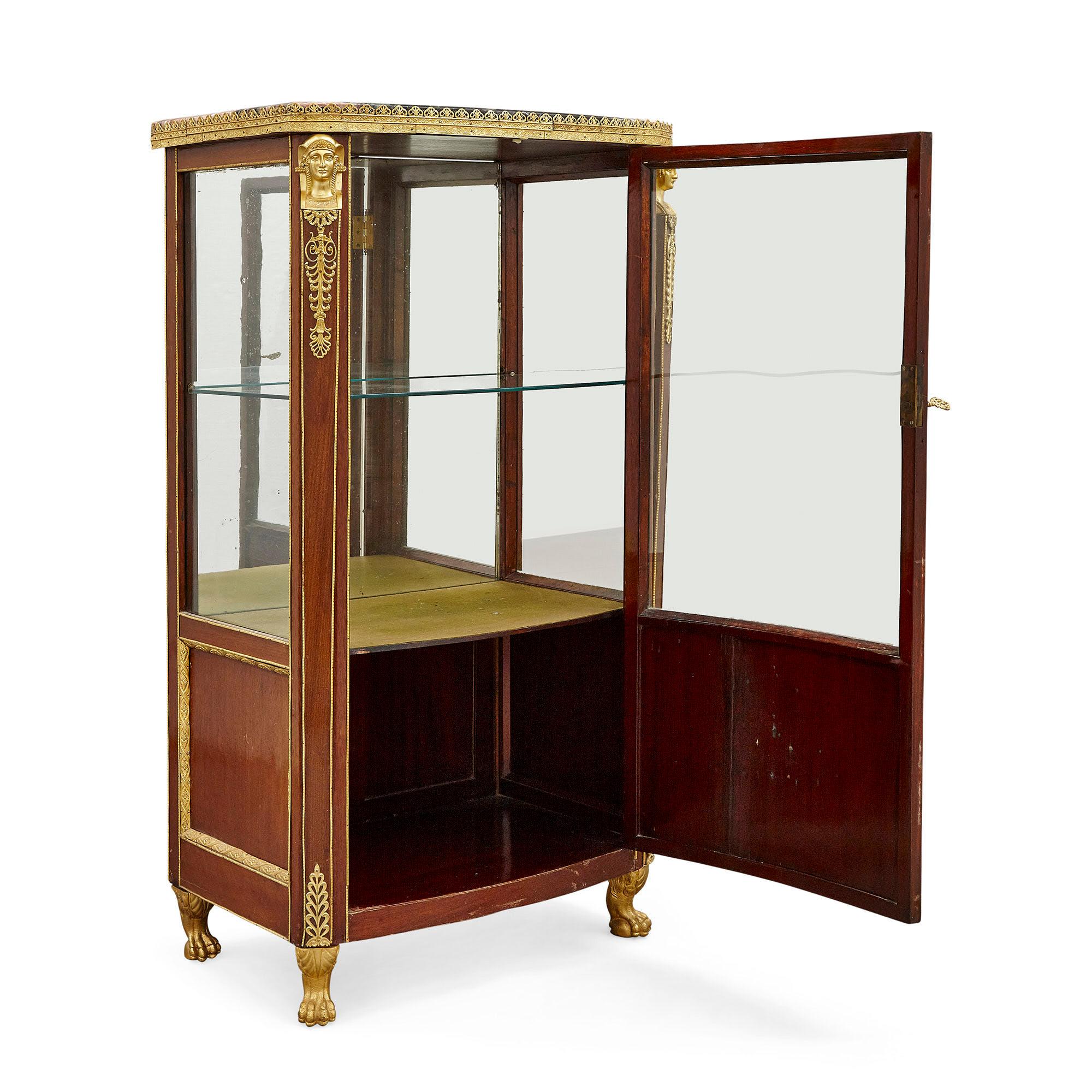 Antique French marble topped vitrine in the Empire style
French, 19th century
Measures: Height 132cm, width 72cm, depth 47cm

This antique mahogany vitrine was made in France and takes after the opulence of French design during the Empire period