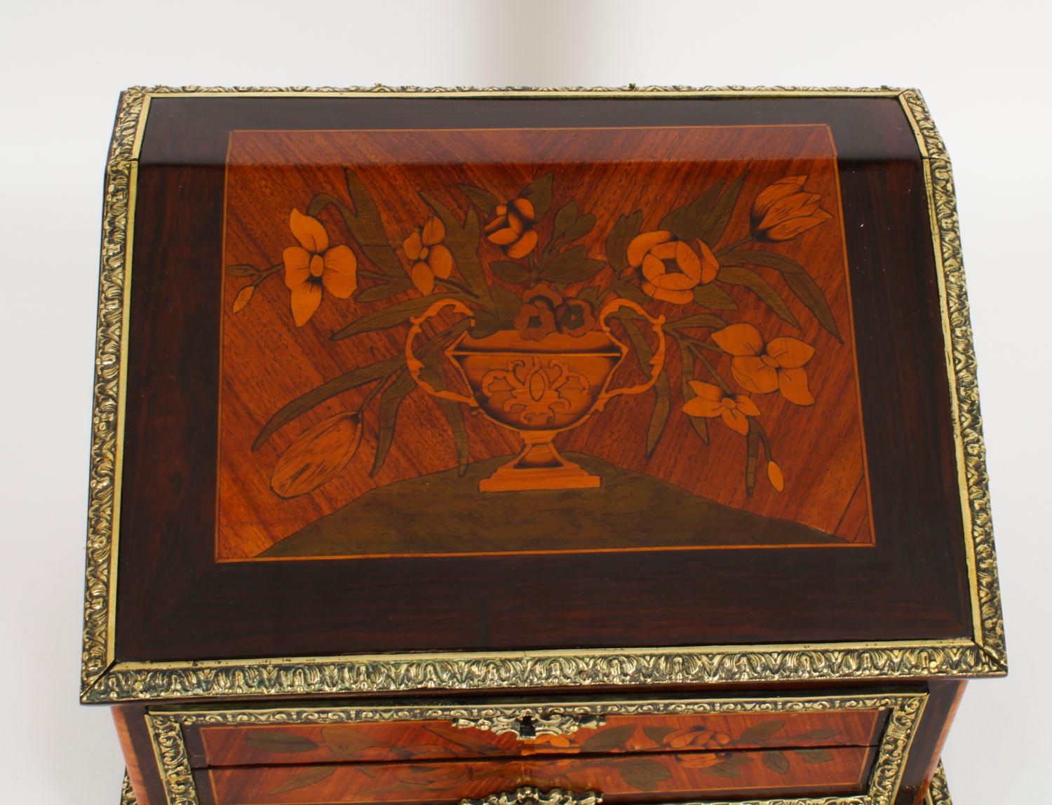Il s'agit d'un magnifique coffret français ancien en marqueterie de Gonçalo Alves et monté en bronze doré, datant d'environ 1860.

Le coffret, de forme A, se soulève et est incrusté d'un vase à fleurs en marqueterie.  qui s'ouvre sur un intérieur