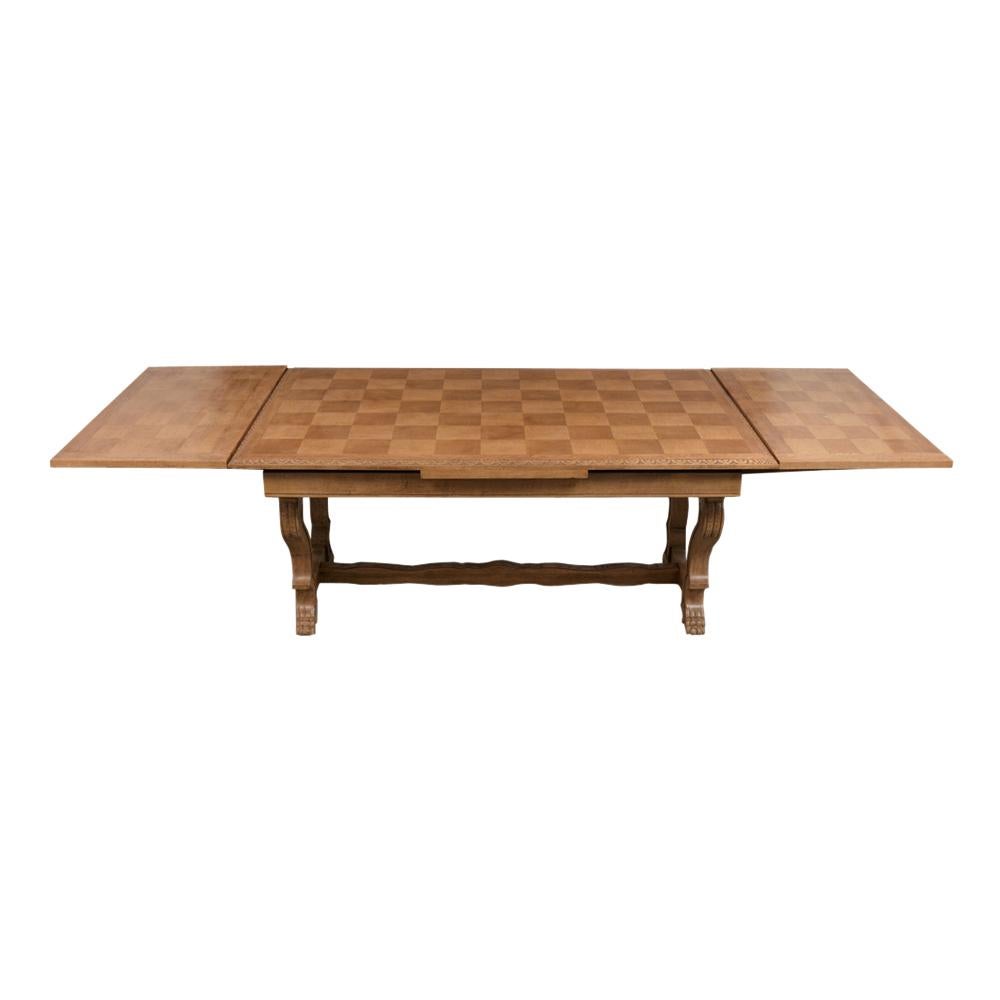 This antique French extendable dining table is in good condition and has been newly bleached and waxed creating a beautiful patina finish. The tabletop has a marquetry design with carved moldings edges, the leaves rest underneath the tabletop and