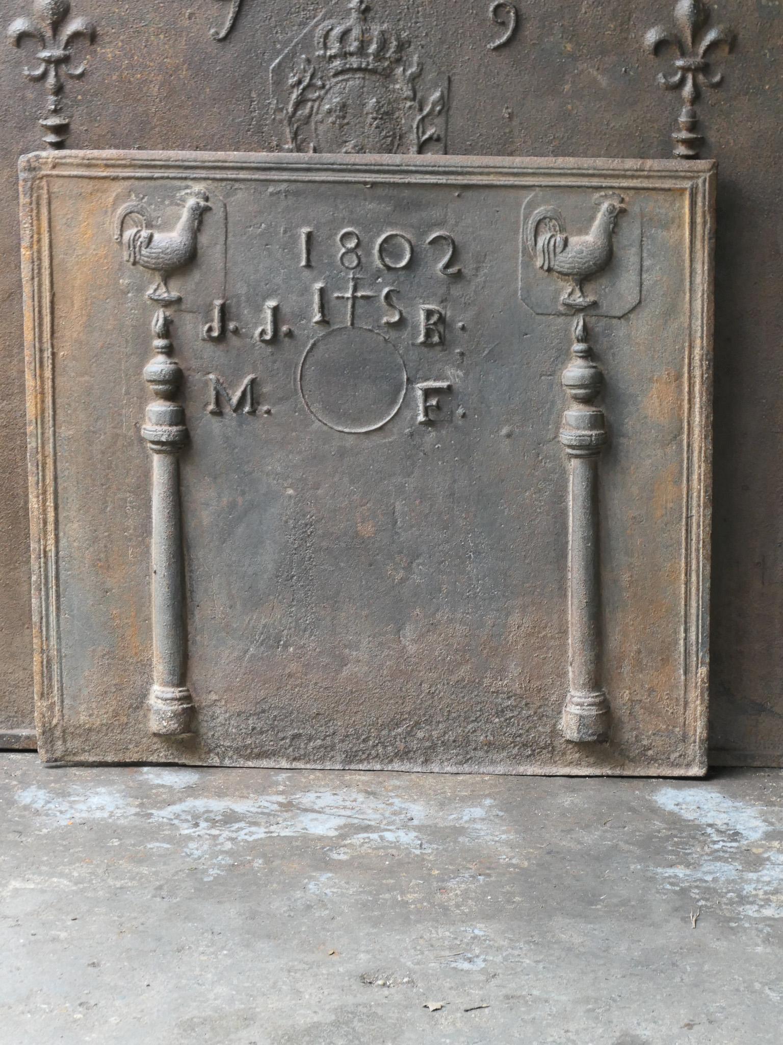 Un parafuoco francese prodotto in onore di un matrimonio nel 1802. Lo schienale del camino è inoltre decorato con due colonne d'Ercole. I pilastri si riferiscono alla clava di Ercole e rappresentano la forza e l'ignoto. L'altra decorazione è