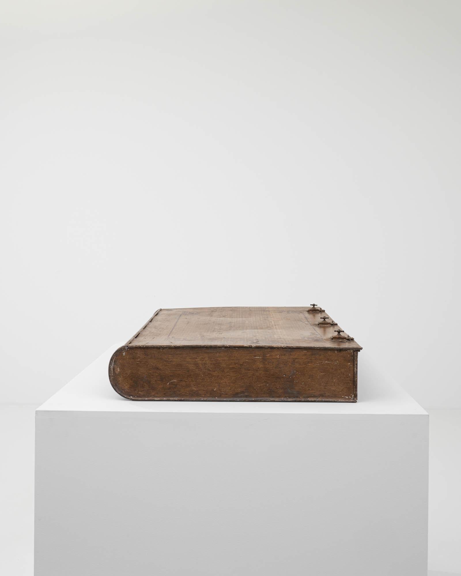 Dieser einzigartige Schatz wurde im 19. Jahrhundert in Frankreich geschaffen. Diese skurrile und einzigartige Metallbox in Form eines ledergebundenen Buches ist mit einem Trompe-l'œil-Finish aus Holzimitat bemalt, das die Textur von Eichenholz