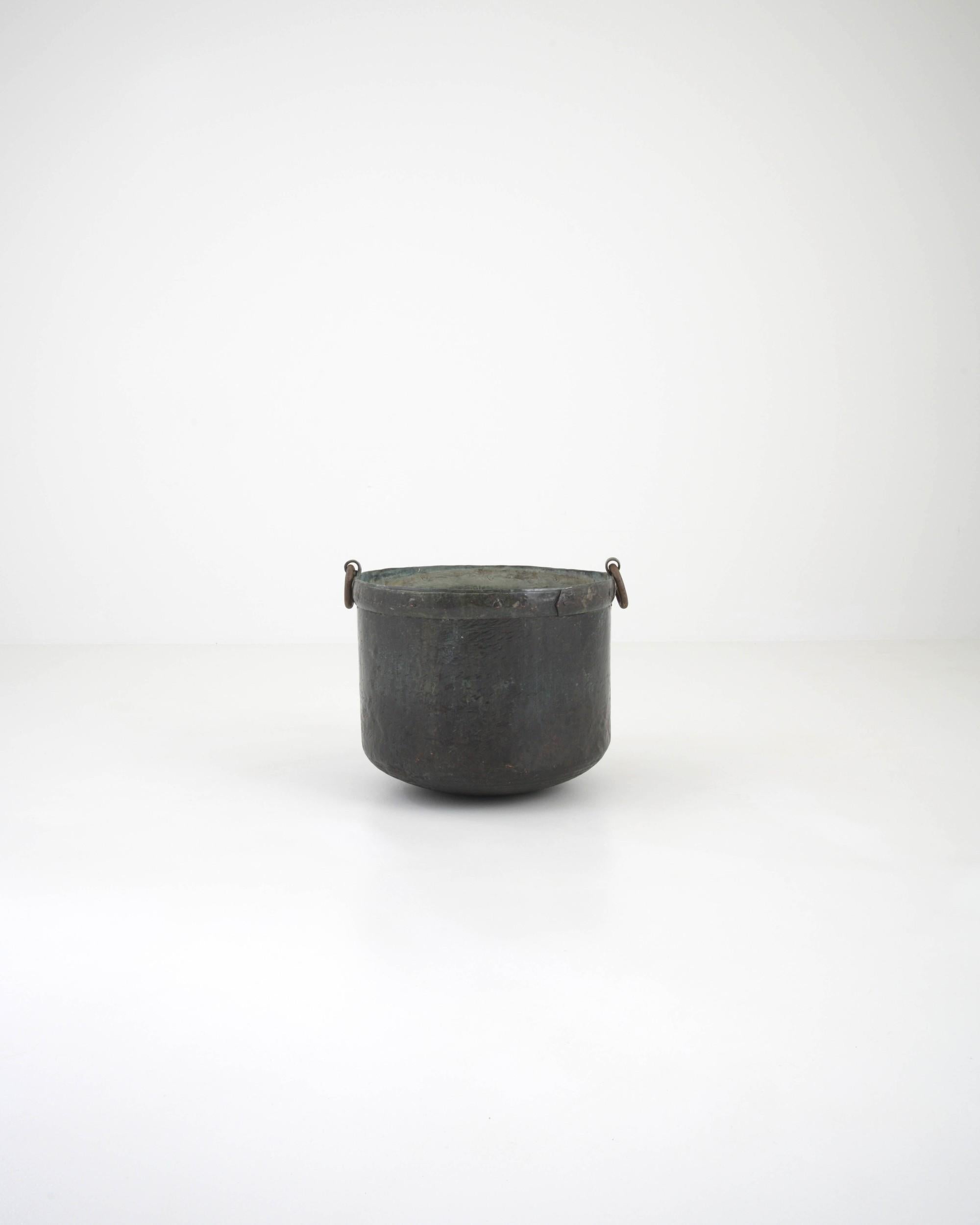A metal pot from 19th Century France. Totally handmade, this pot features a beautiful oxidized patina layering the original polished finish. These artisanally crafted pots were made with care and detail, along with high quality materials produced