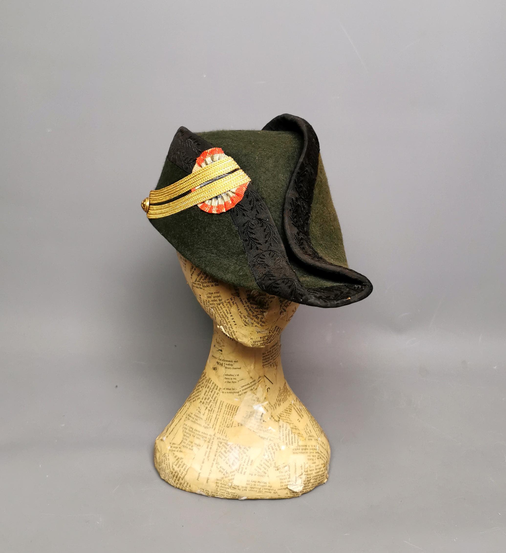 A fantastic antique French bicorn military hat.

This gorgeous and scarce piece is not only a piece of fashion history but also a fantastic military relic.

It is made from a deep forest green felt, very stiff and well formed.

The hat is trimmed in