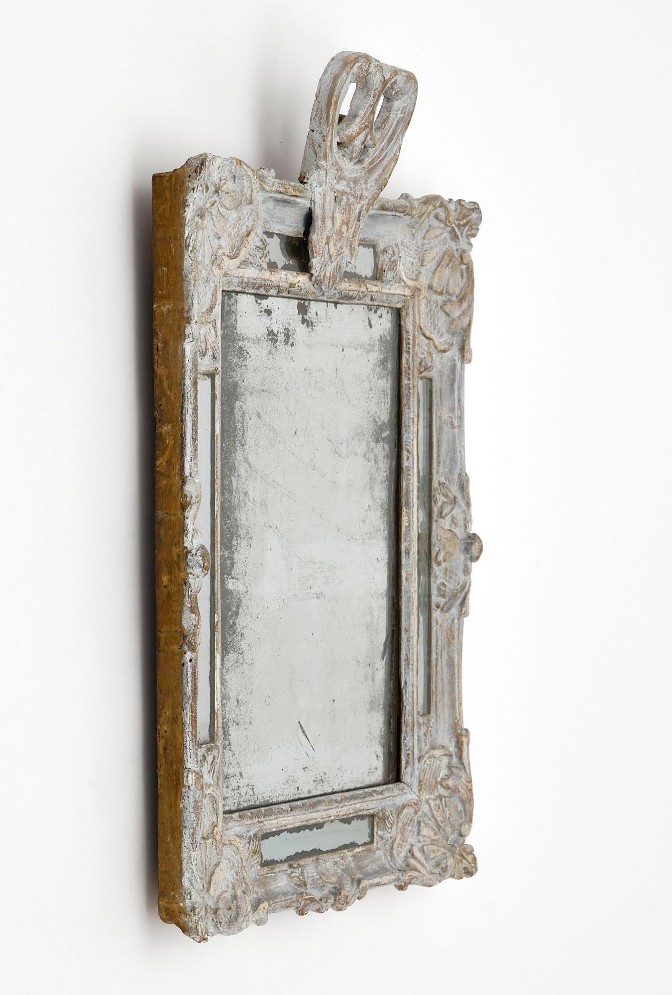 Miroir français ancien avec un cadre en bois de style Regency sculpté à la main. La finition et la peinture sont entièrement d'origine. Nous adorons la patine et le miroir au mercure d'origine.