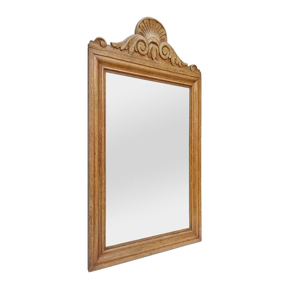 Antique French mirror from the 1950s in light oak with carved pediment. Antique frame width: 5 cm / 1.96 in. Modern glass mirror. Wood back.