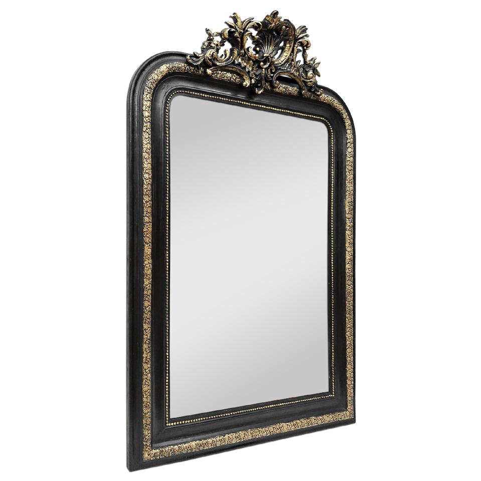 Antique French wall mirror with pediment, Napoleon III period (Second Empire style), black and gilt. Antique frame adorned with pearls (frame width: 9,5 cm / 3.75 in.) and floral patterns. Decorative shell pediment with stylized foliages. Re-gilding