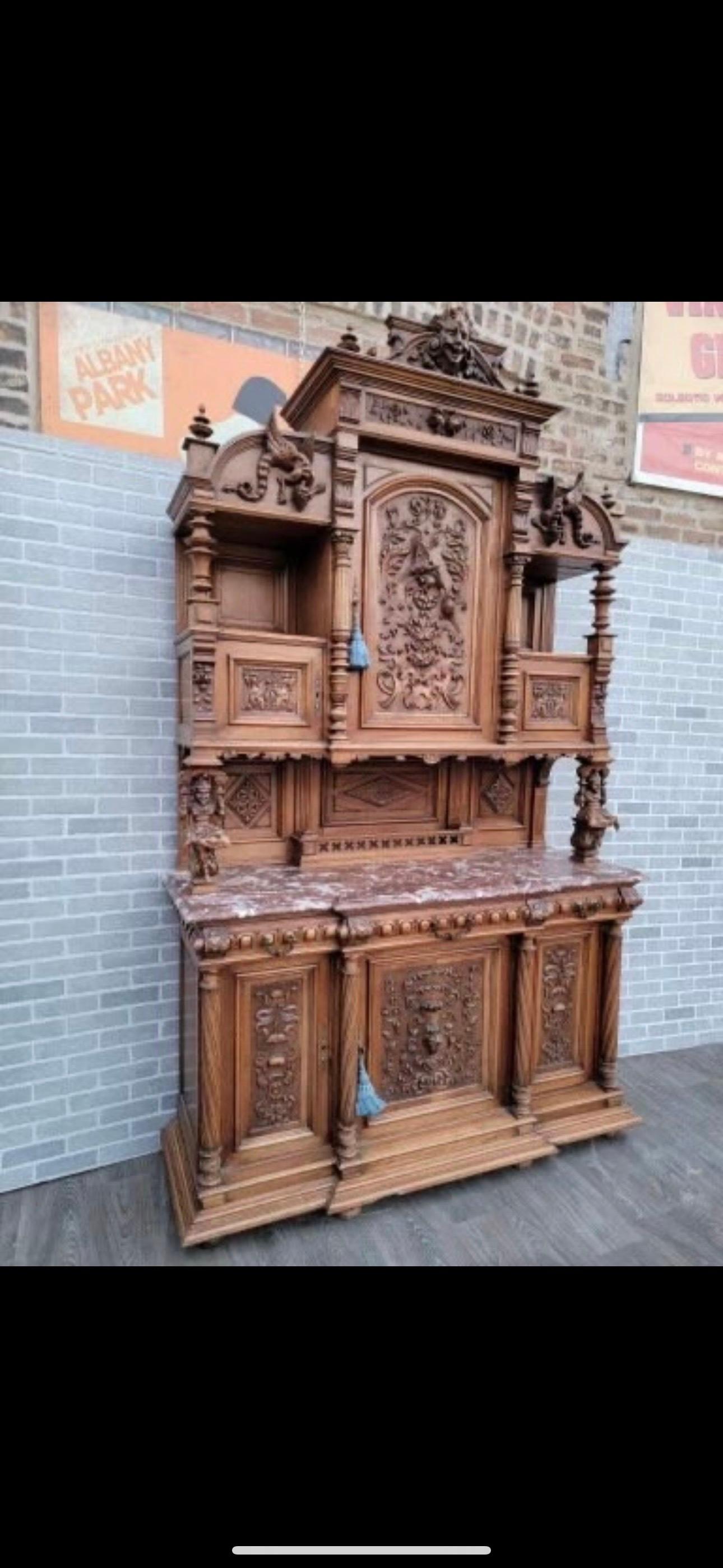 Antique French Monumental Hand Carved Ornate Figural Walnut Commissioned Chateau Cabinet

An elaborate antique imported from France finely hand carved walnut chateau cabinet. A high quality commission cabinet with full figure jesters, lion faces,