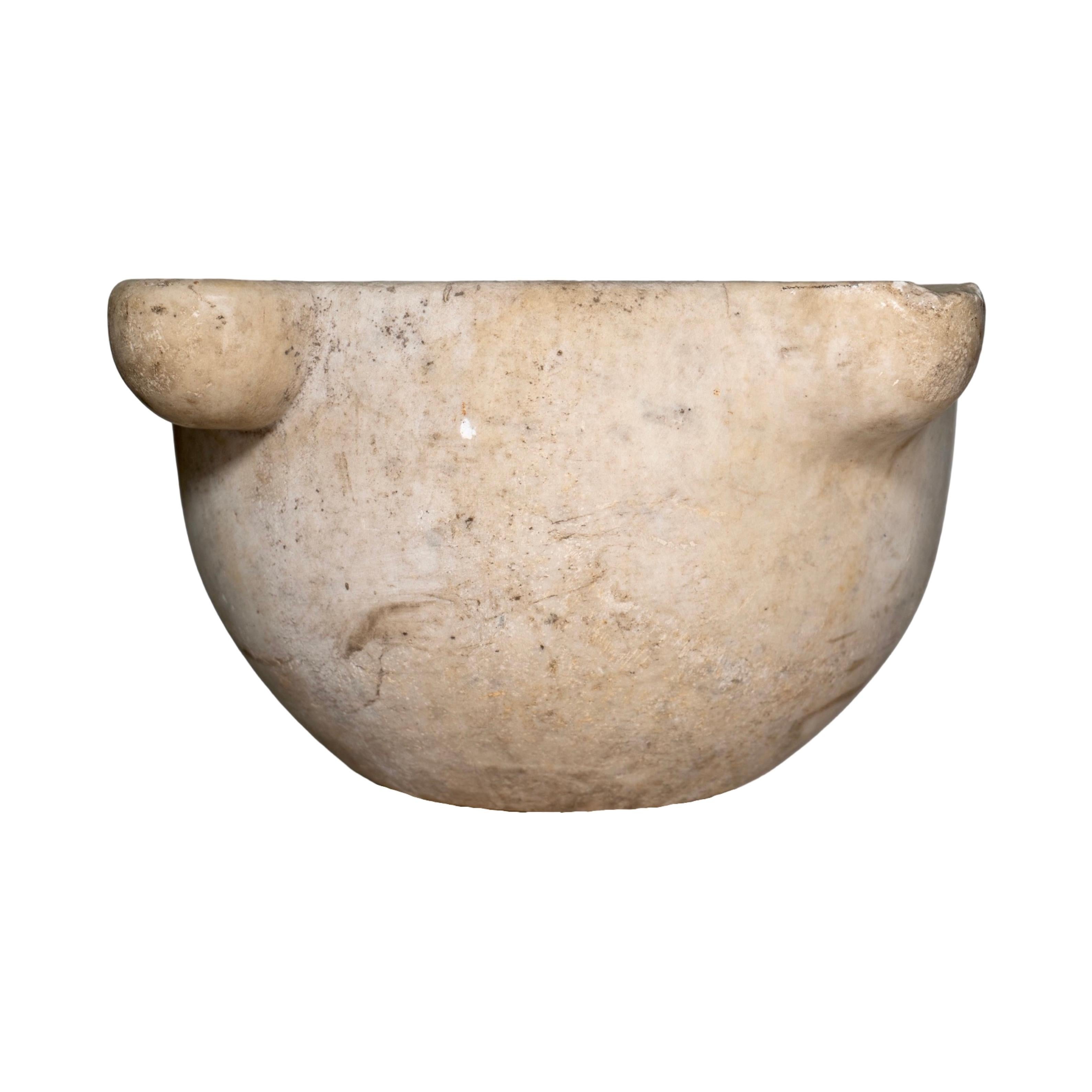 Hand-carved in France during the 19th century, this solid marble mortar bowl showcases a timeless, utilitarian form softened by the natural patina earned over generations of use. Originally crafted for grinding herbs and spices, its weight and