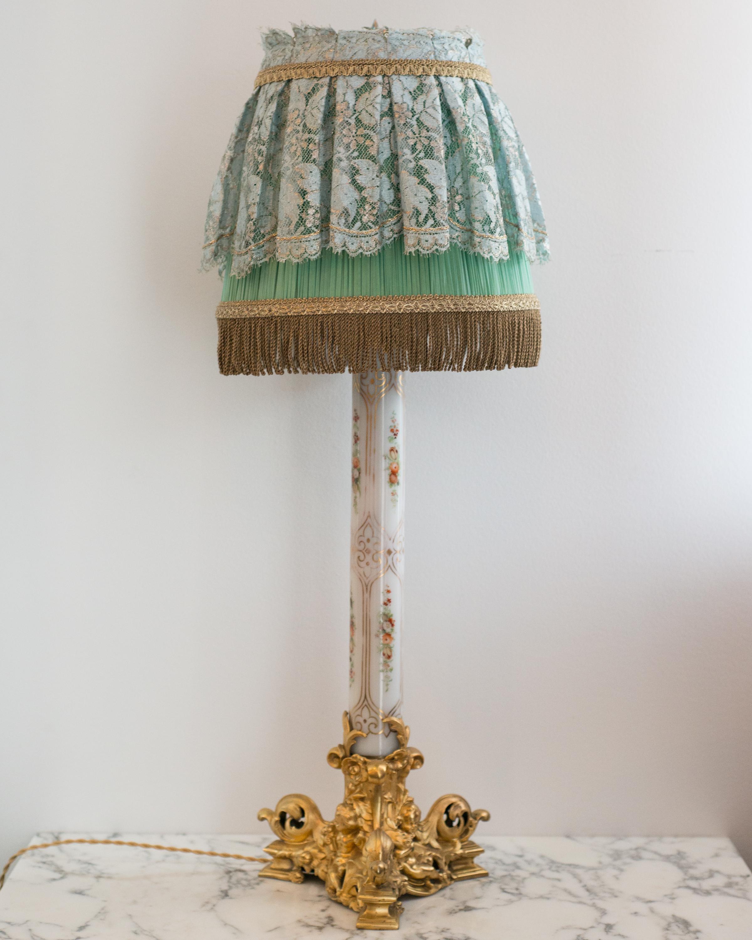 A unique French Napoleon III opaline glass lamp with gilt and flower details on an ornate bronze base, newly rewired with a magnificent shade of lace, pleated silk and metallic bullion trim.

