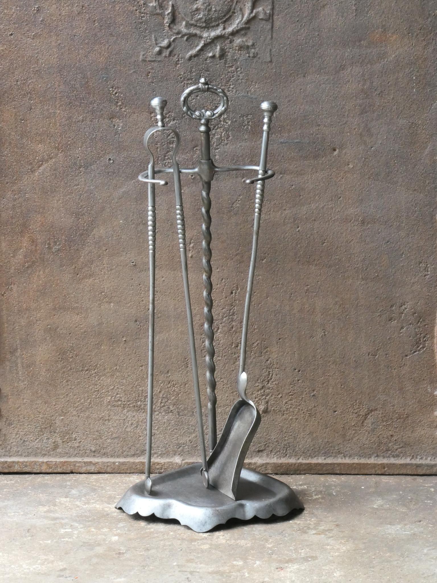 19th century French fireplace tool set. Napoleon III period. The tool set consists of tongs, shovel, and a stand. The tool set is hand forged and made of wrought iron. The set is in a good condition. Fit for use in the fireplace.