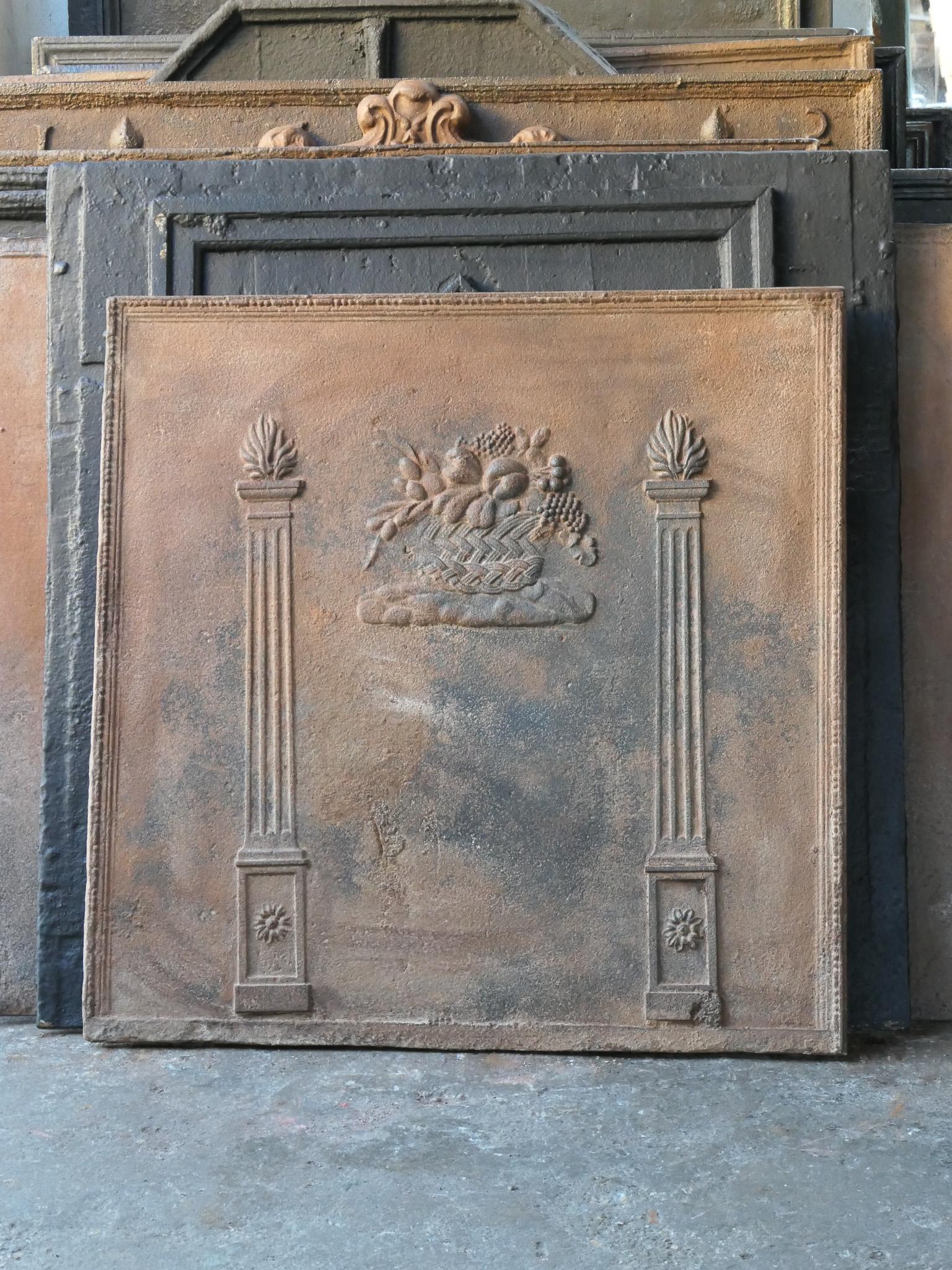 Early 19th century French Napoleon III fireback with pillars of freedom and a fruit basket. 

The fireback is made of cast iron and has a brown patina. Upon request it can be made black / pewter with stove polish at no extra cost. It can be used in