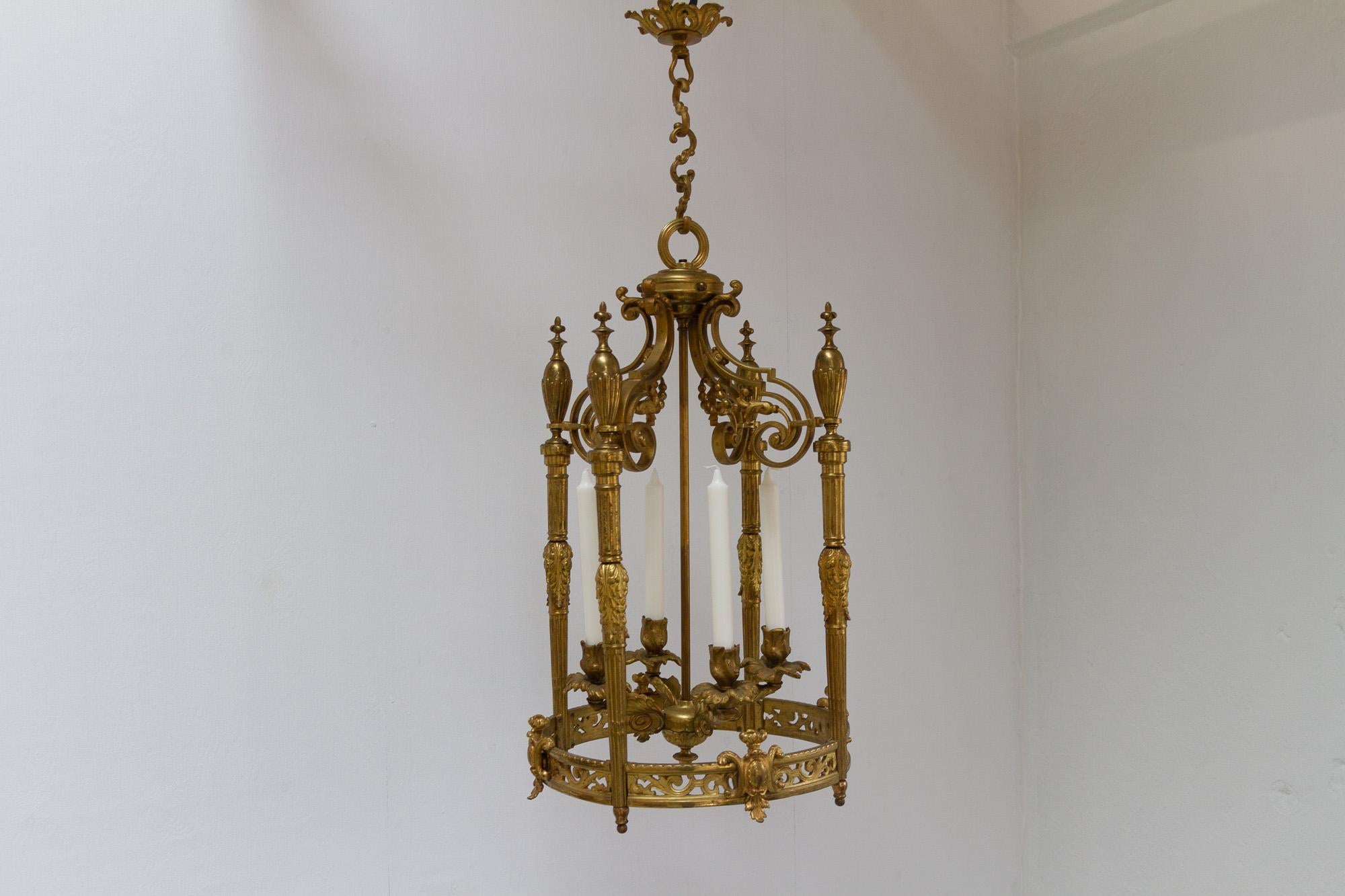 Antiker französischer Napoleon-III-Kronleuchter aus vergoldeter Bronze, 1850er Jahre.
Eleganter, laternenförmiger Hängekronleuchter für vier Kerzen. Aufgehängt an einem Baldachin mit dreigliedriger Kette. 
Vergoldete Bronze (Ormolu) mit vielen
