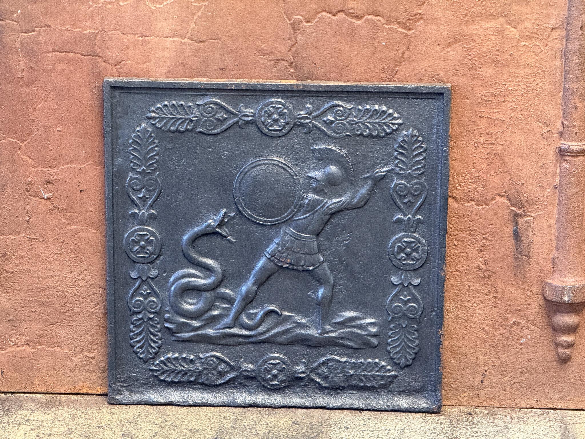 19th century French Napoleon III 'Hercules and the Snake' fireback / backsplash.

The fireback is made of cast iron and is black / pewter colored. The fireback is in a good condition and does not have cracks.