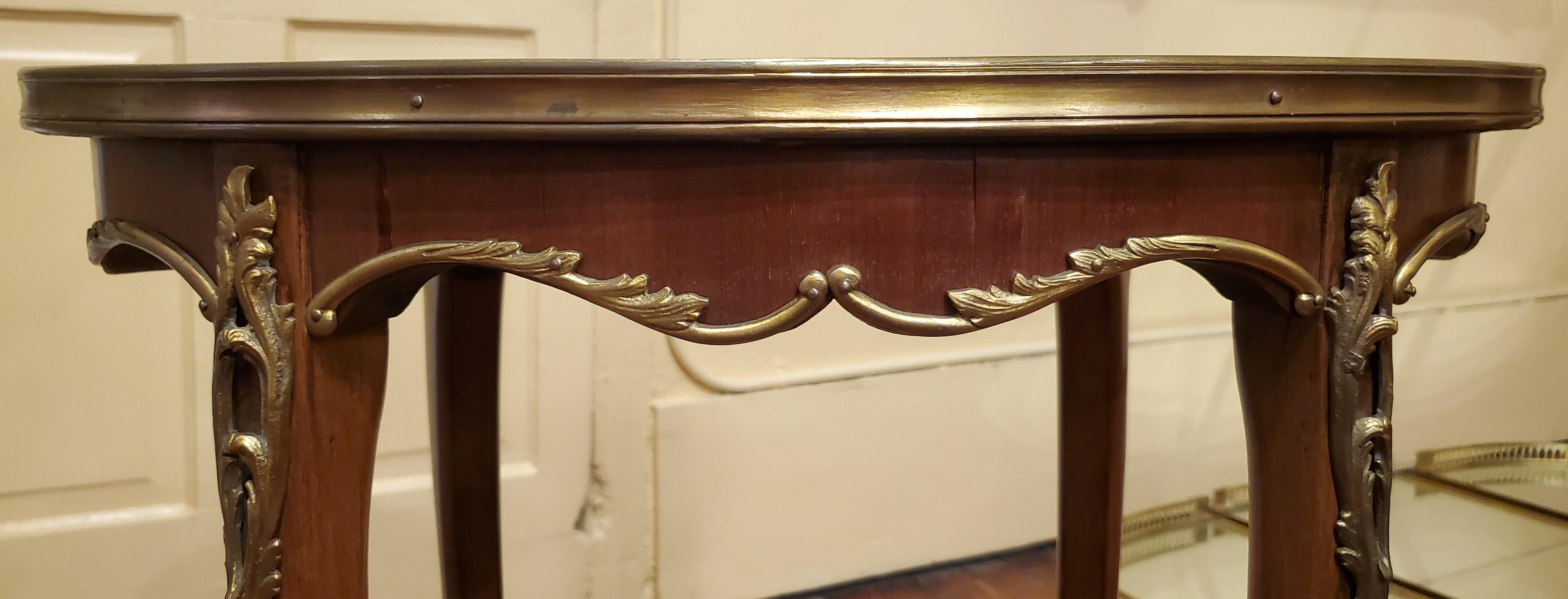 Table d'appoint ancienne Napoléon III en acajou et bronze doré. Cette table est de forme ovale.