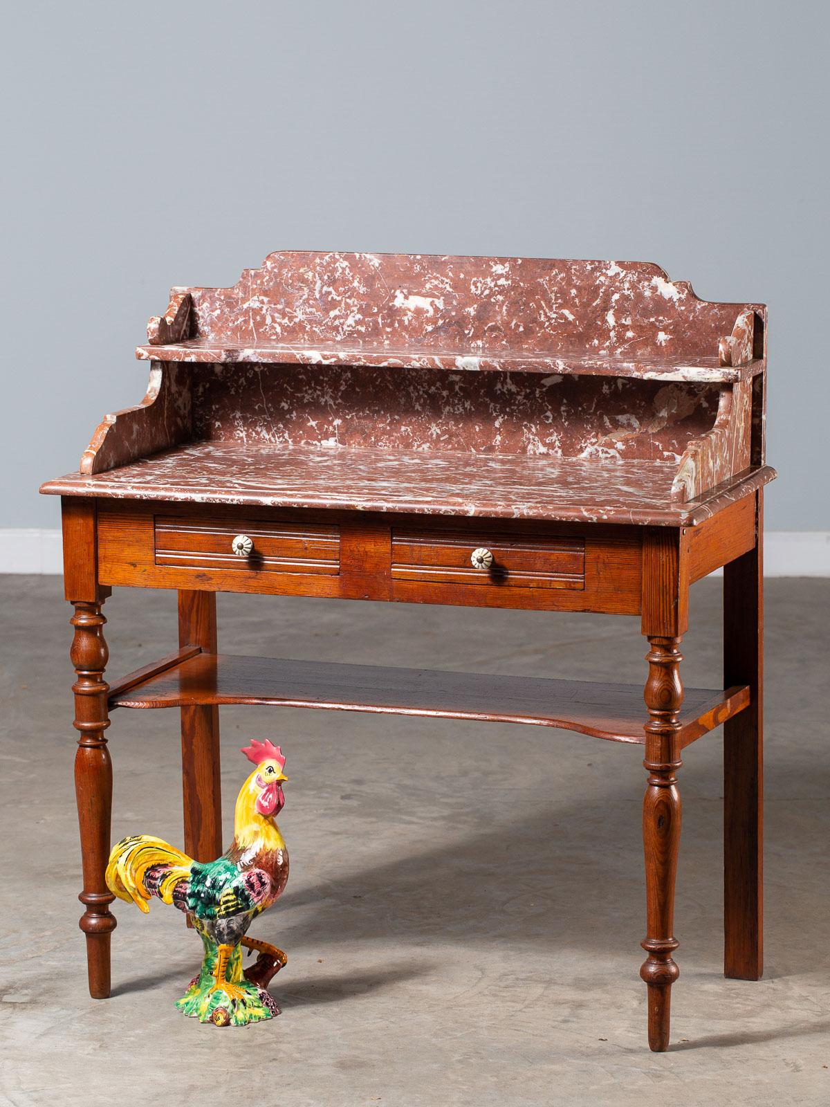 A Classic antique French Napoleon III period marble pine washstand having two drawers and a lower shelf. We are impressed by the heavy and substantial marble top hand assembled from seven individual pieces of handcut marble designed to create a