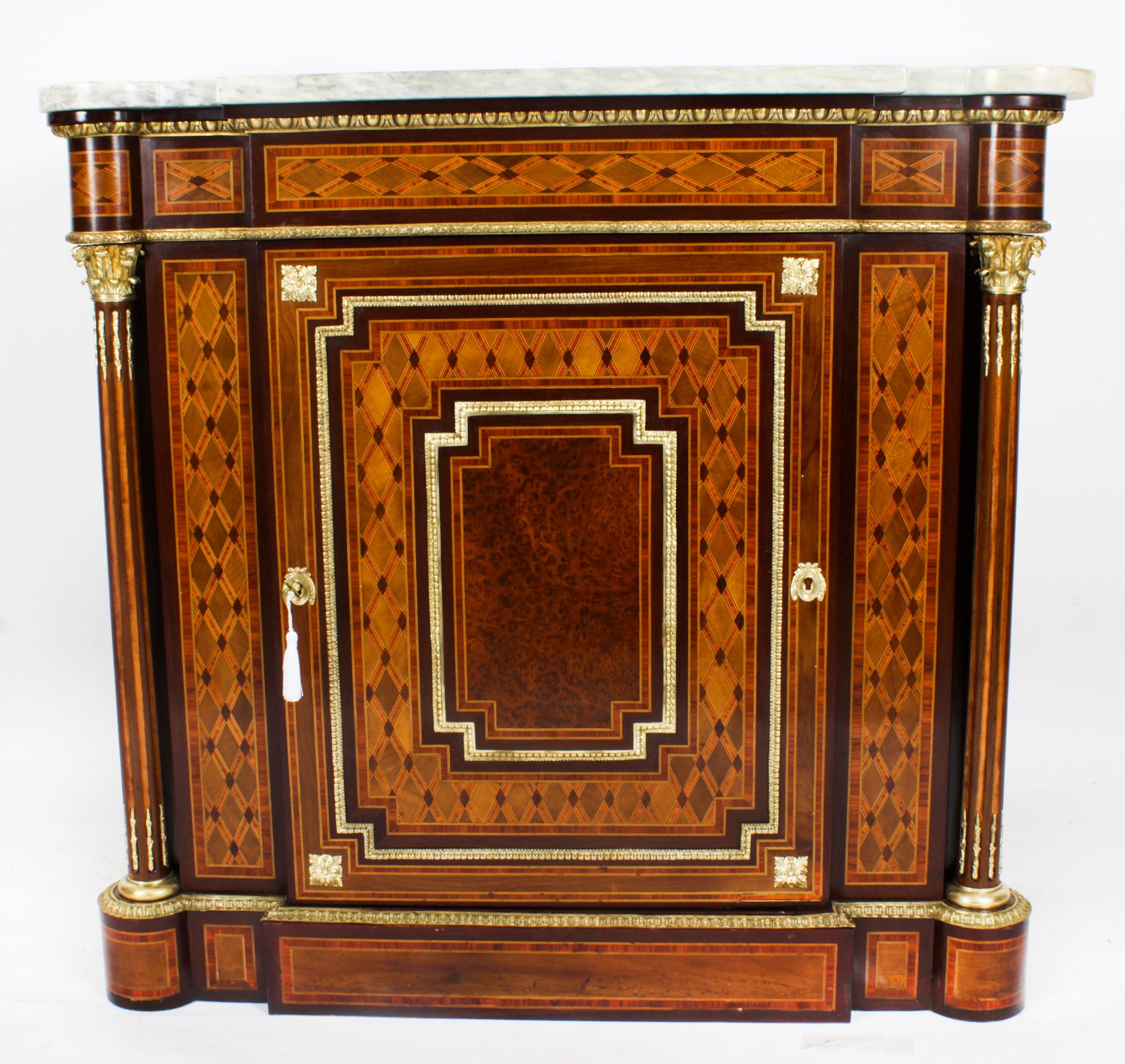 This is a fabulous antique French Napoleon III burr walnut, bois de violette and ormolu mounted parquetry pier cabinet surmounted with the original striking Pierre Gris, marble top, circa 1860 in date.
 
The cabinet has an elegant geometric mosaic