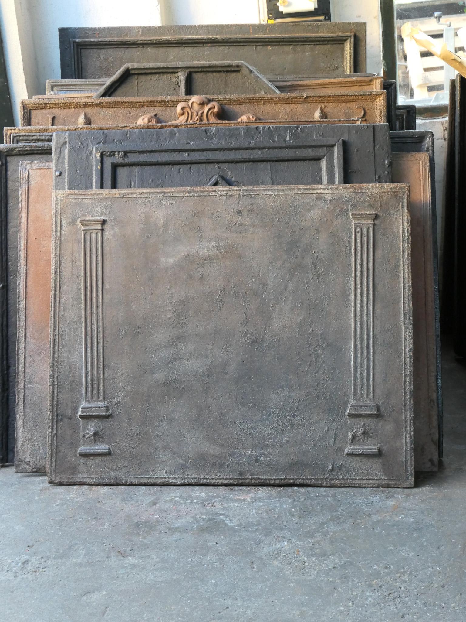 Late 18th - early 19th century French Neoclassical fireback with two pillars of freedom. The pillars symbolize the value liberty, one of the three values of the French revolution. 

The fireback is made of cast iron and has a brown patina. Upon