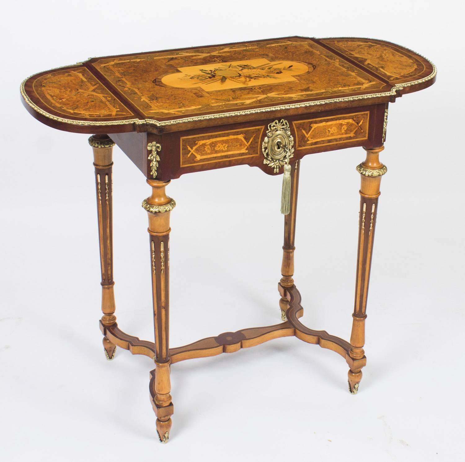 This is a wonderful antique French Napoleon III marquetry and ormolu mounted Poudreuse or writing table, circa 1860 in date.

The stunning marquetry lift up top is decorated with musical instruments, flowers and garlands and has a flap on each side