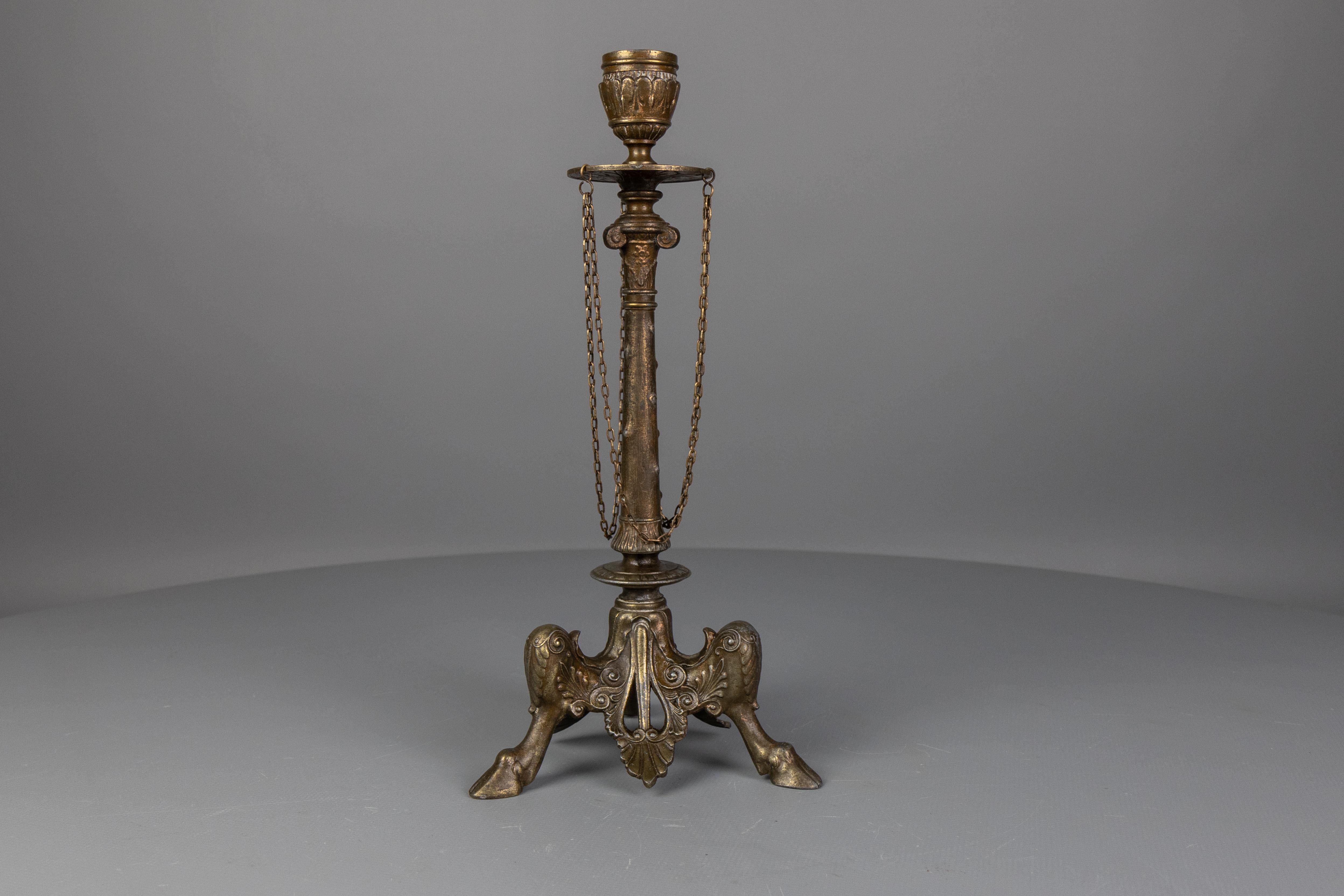 Antico candeliere francese del periodo Napoleone III in spelta bronzata, fine del XIX secolo.
Questo antico portacandele presenta un disegno drappeggiato con catene ed è sostenuto da una base a tre piedi. La colonna centrale è decorata con motivi di