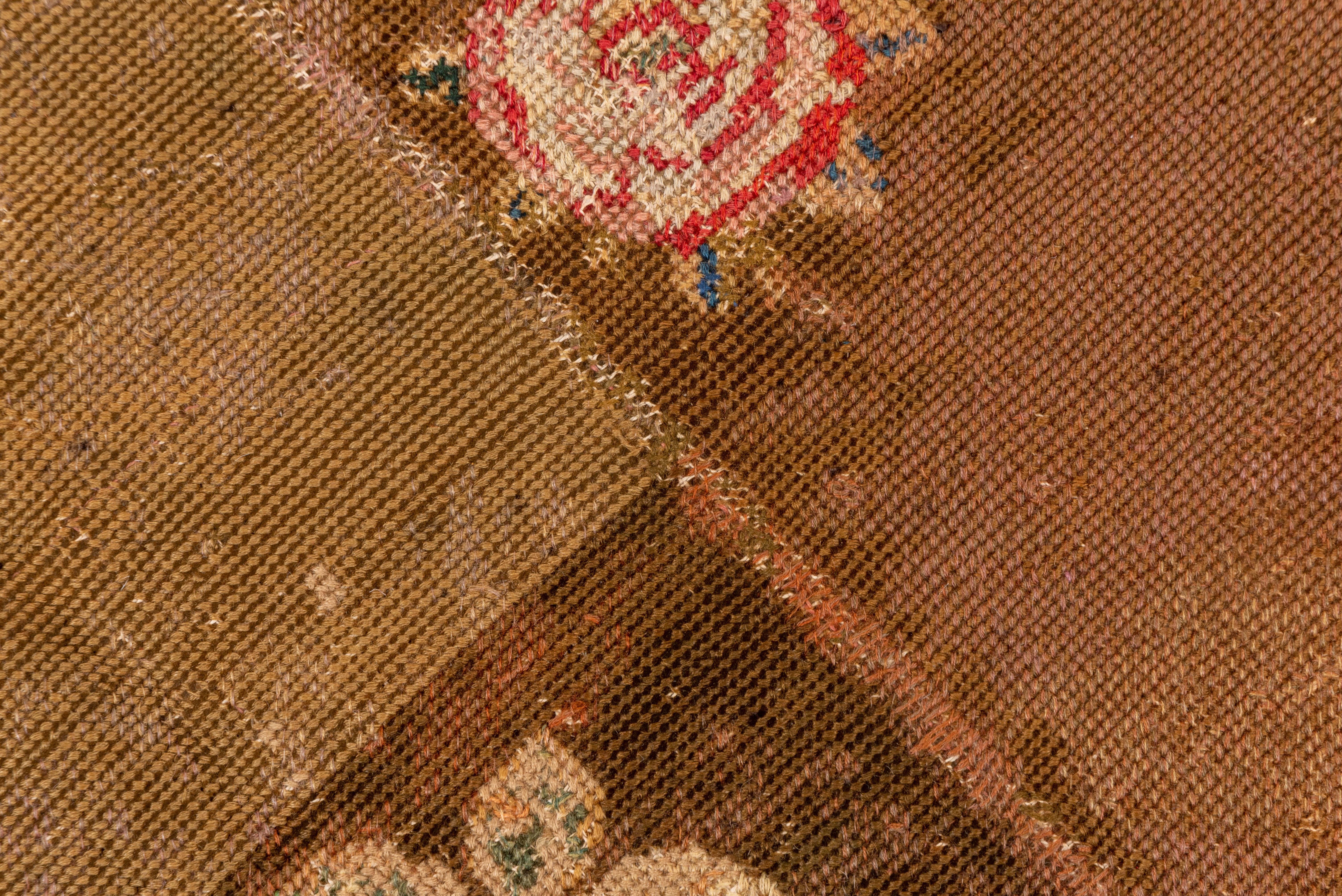 The clearly sectioned rust brown field displays offset rows of rose bouquets, all around a layered round medallion in bubble-gum and buff with a central leaf octofoil. Pink border with a rose pattern.