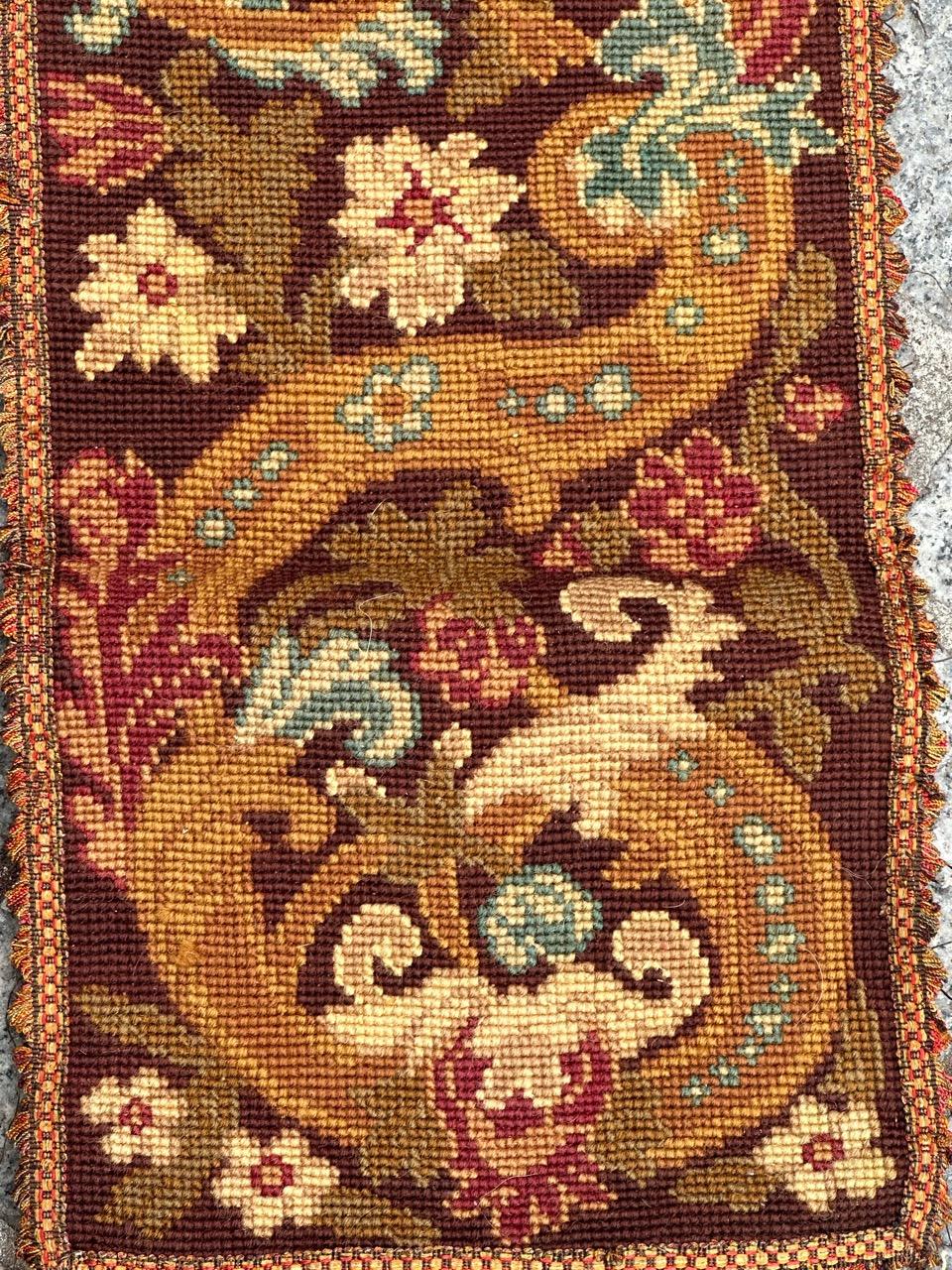 Precioso tapiz de finales del siglo XIX en forma de franja o fragmento de cenefa, con bonito diseño floral y bellos colores, bordado totalmente a mano con el método de punto de aguja con lana y seda sobre base de algodón.