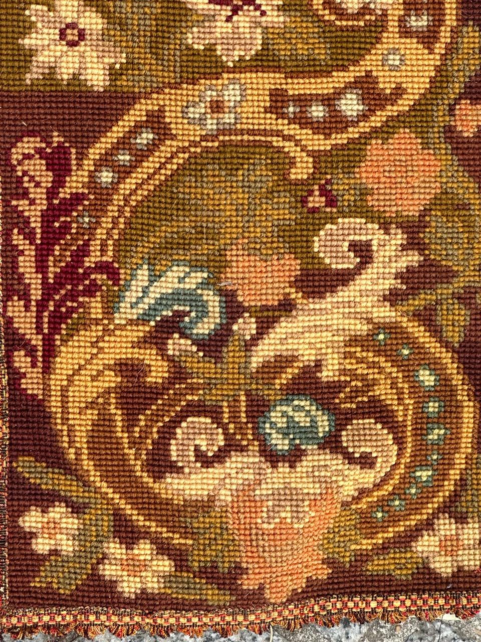 Precioso tapiz de finales del siglo XIX en forma de franja o fragmento de cenefa, con bonito diseño floral y bellos colores, bordado totalmente a mano con el método de punto de aguja con lana y seda sobre base de algodón.