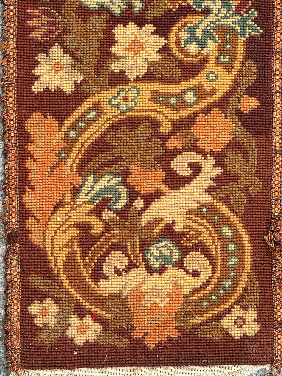 Precioso tapiz de finales del siglo XIX en forma de franja o fragmento de cenefa, con bonito diseño floral y bellos colores, bordado totalmente a mano con el método de punto de aguja con lana y seda sobre base de algodón.