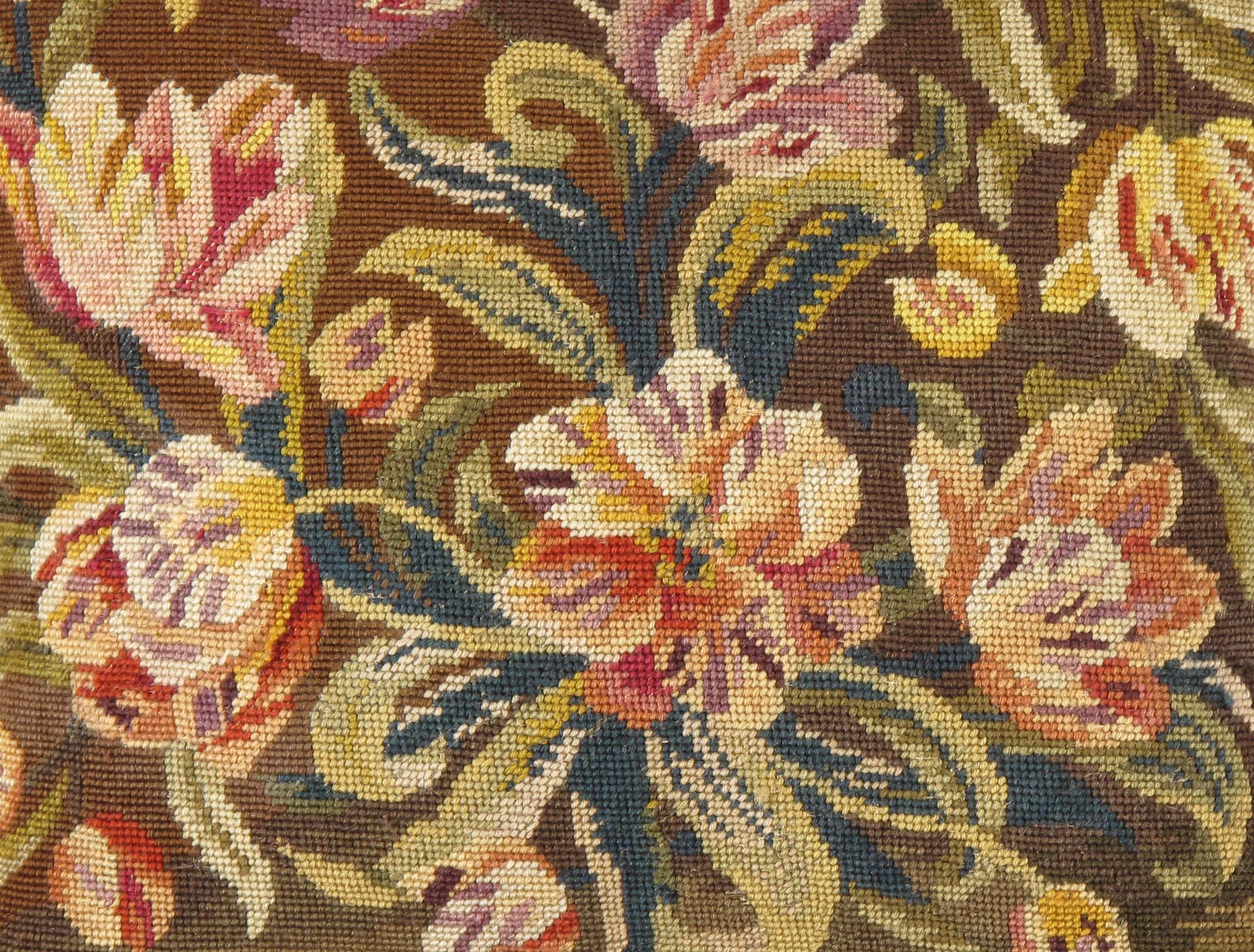 Antique French needlepoint pillow 1'6 x 1'8. An antique French needlepoint pillow. The floral needlepoint is antique the cushion and backing are new Colors: browns/greens/purple/rose.
  