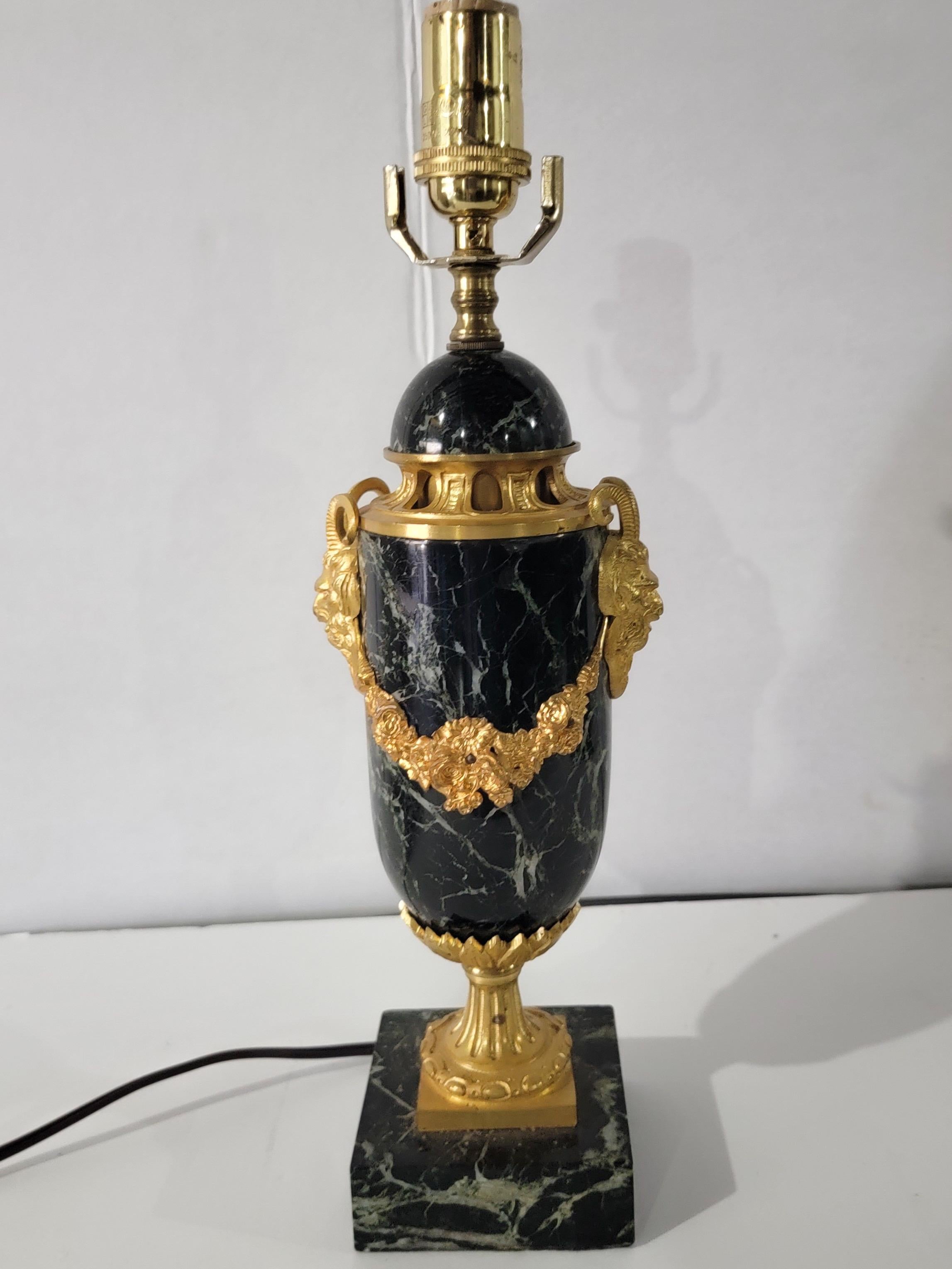 This is a lovely antique French neo-classical style gilt bronze and black veined marble lamp. It has a urn form with draped gilt bronze floral foliate. It is unmarked and in working order.
 