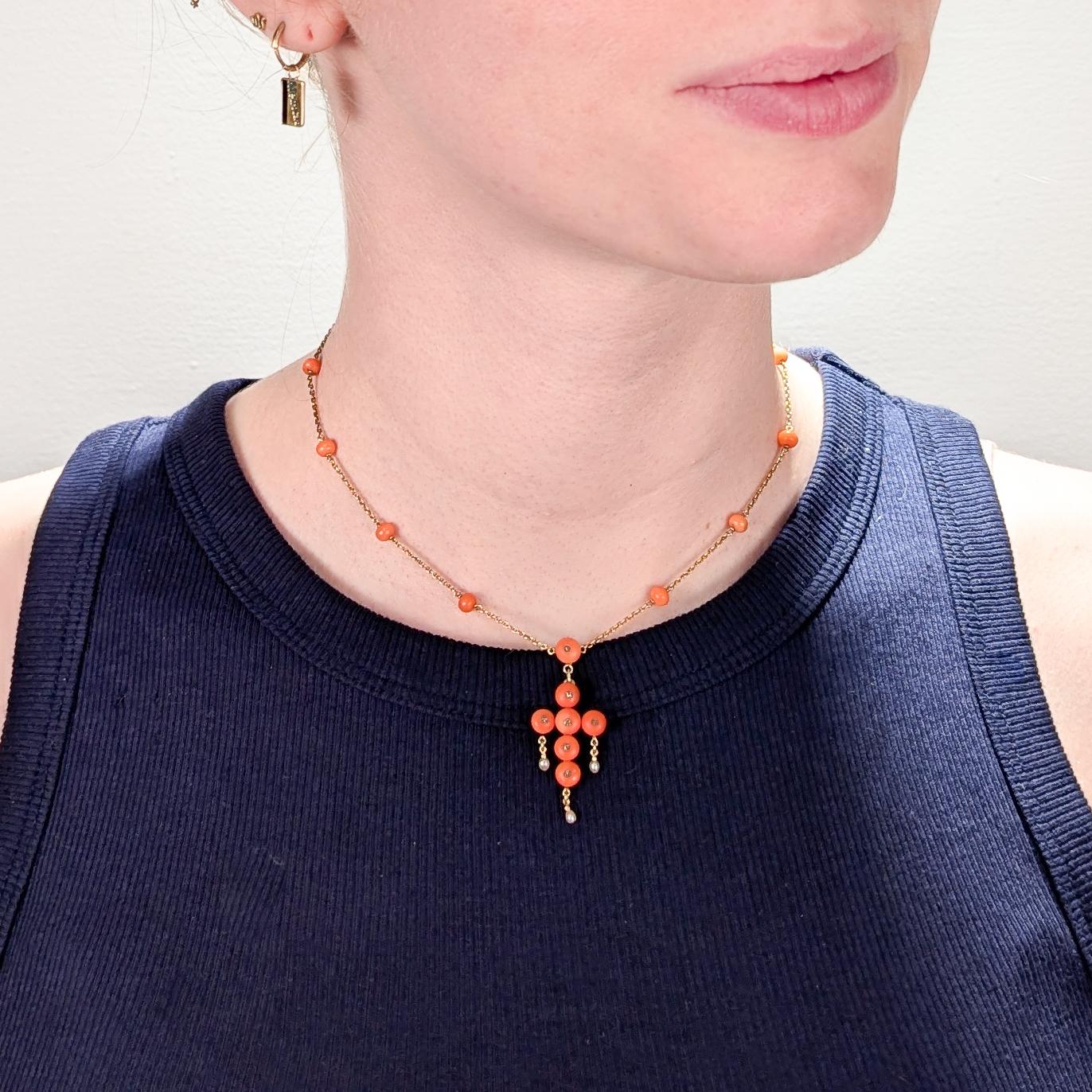 A fine antique French gold, coral, and diamond pendant necklace.

In 18 karat yellow gold.

The pendant with coral beads set in the form of a cross and the chain interspersed with evenly spaced coral beads. 

Each bead in the cross  set with a small