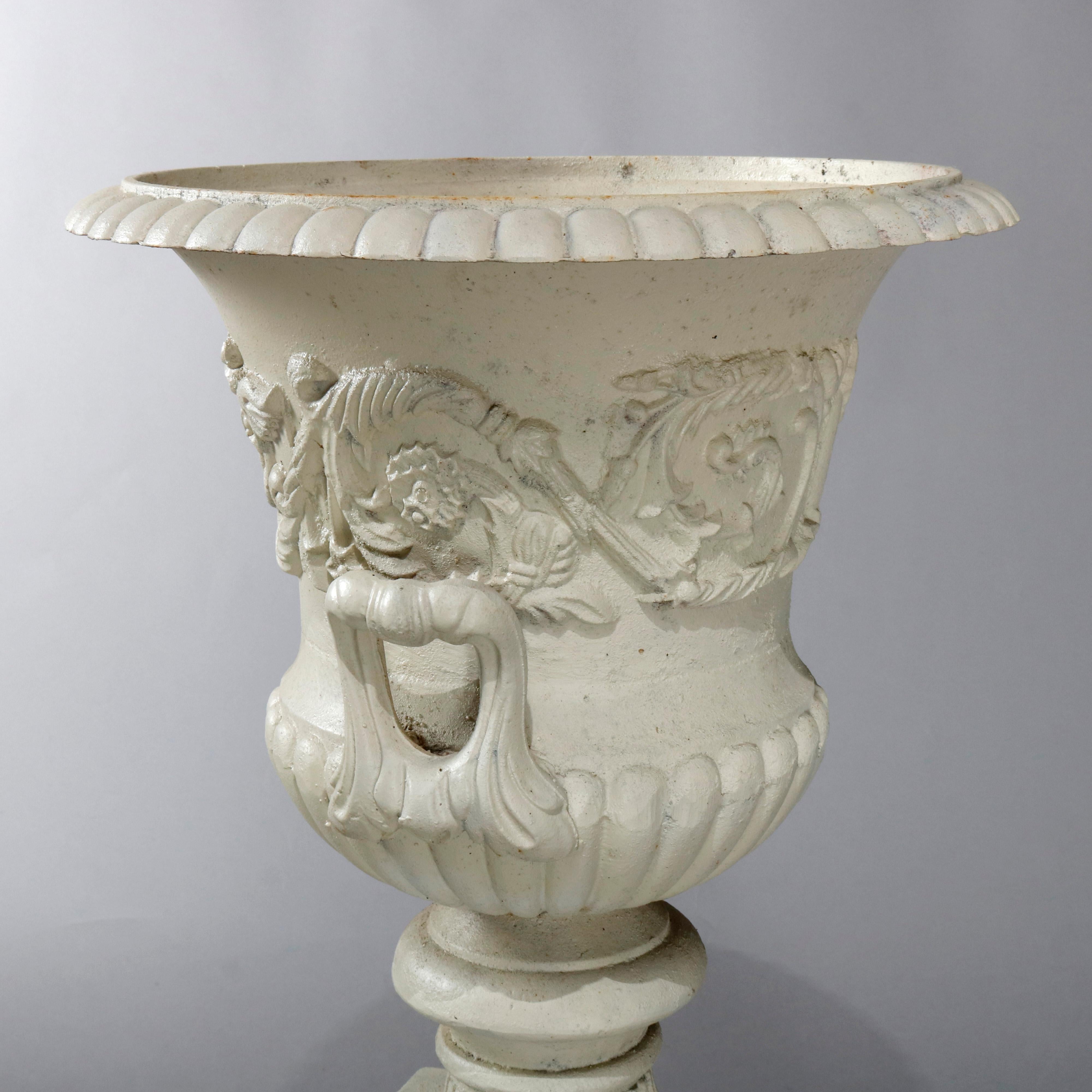 An antique French neoclassical garden urn offers central foliate and scroll relief band and double handles, seated on square and stepped base, separates into two parts, 20th century

Measures: 36