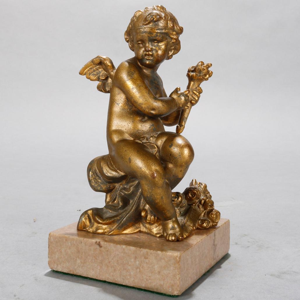 An antique French neoclassical figural sculpture offers bronzed metal casting and depicts a seated and winged cherub holding a torch, seated on marble plinth with velvet lining, circa 1890.

Measures: 7