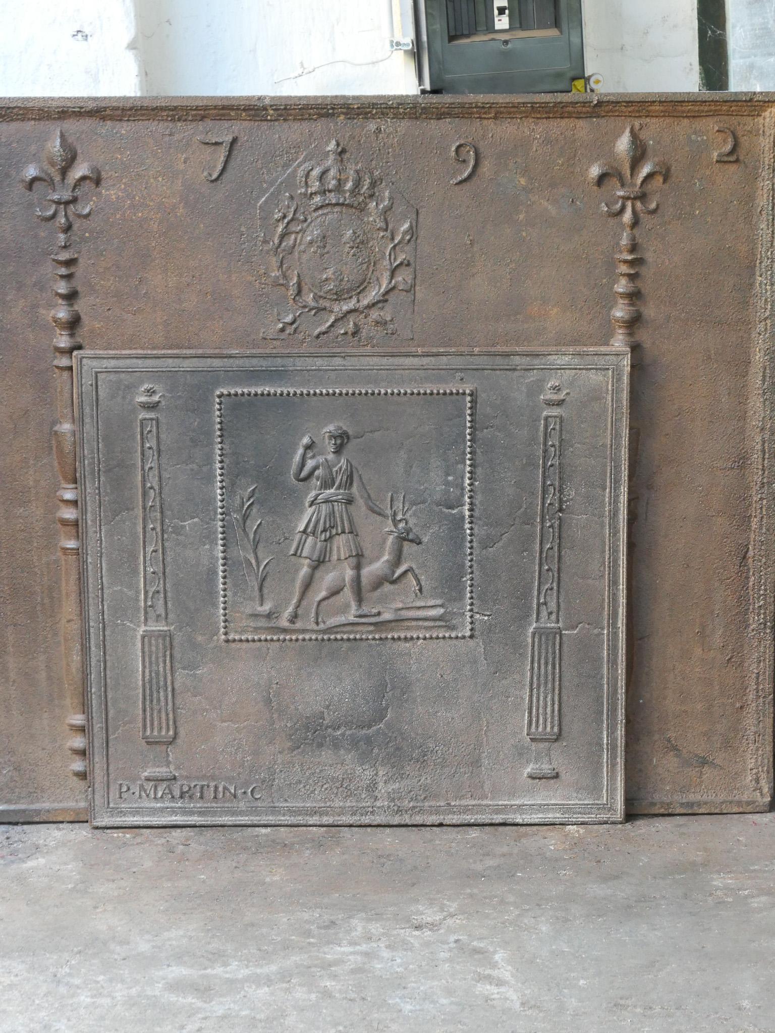 Neoklassizistischer französischer Kaminboden aus dem 18. bis 19. Jahrhundert mit der Darstellung eines Jägers und eines Hirsches, flankiert von zwei Säulen der Freiheit.

Die Feuerrückwand ist aus Gusseisen und hat eine braune Patina. Auf Wunsch
