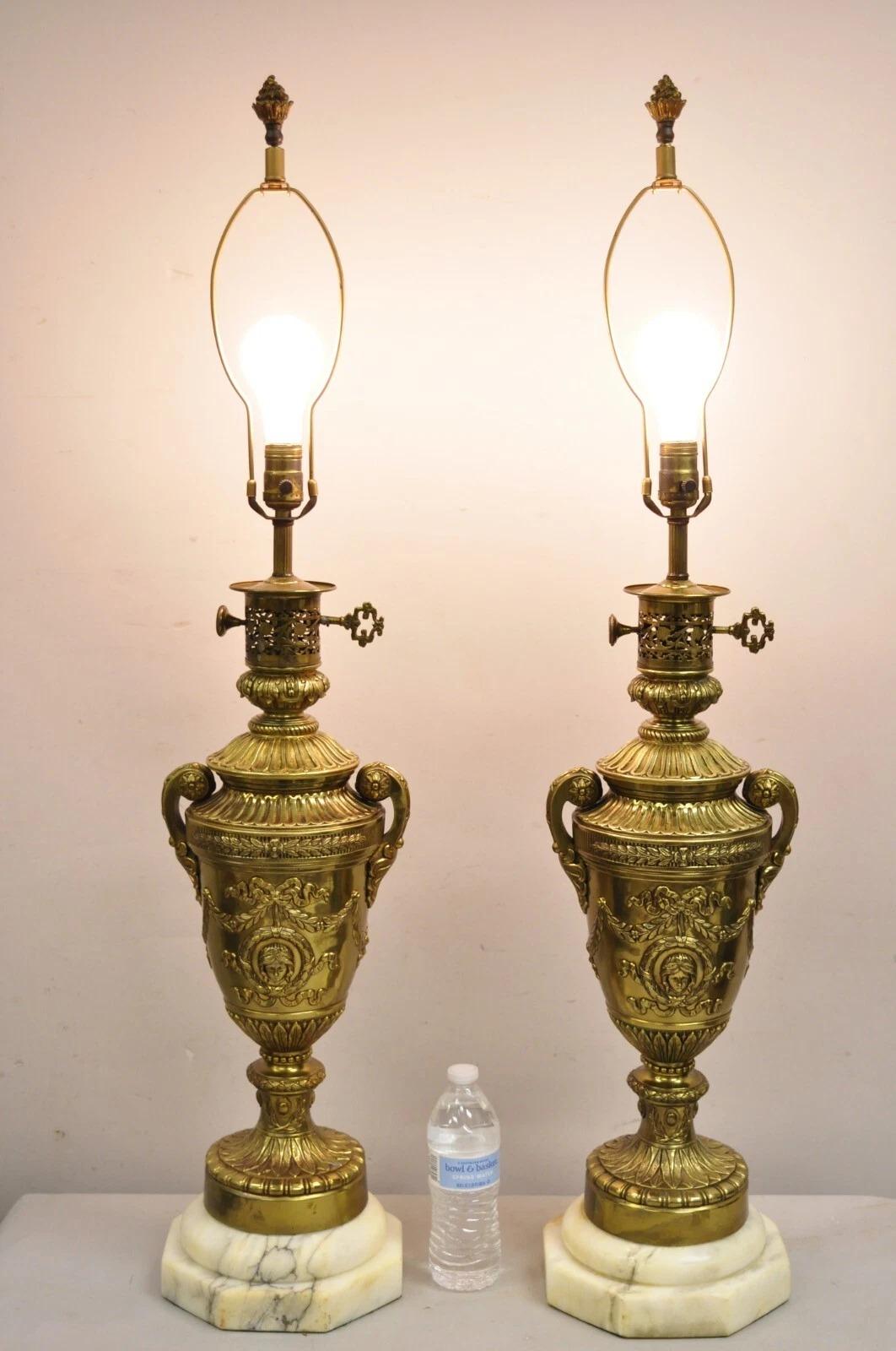 Superbe paire de lampes de table en bronze doré de style Empire français en forme d'urne avec des couronnes et des visages de jeunes filles sur des bases en marbre à gradins. Monogramme 