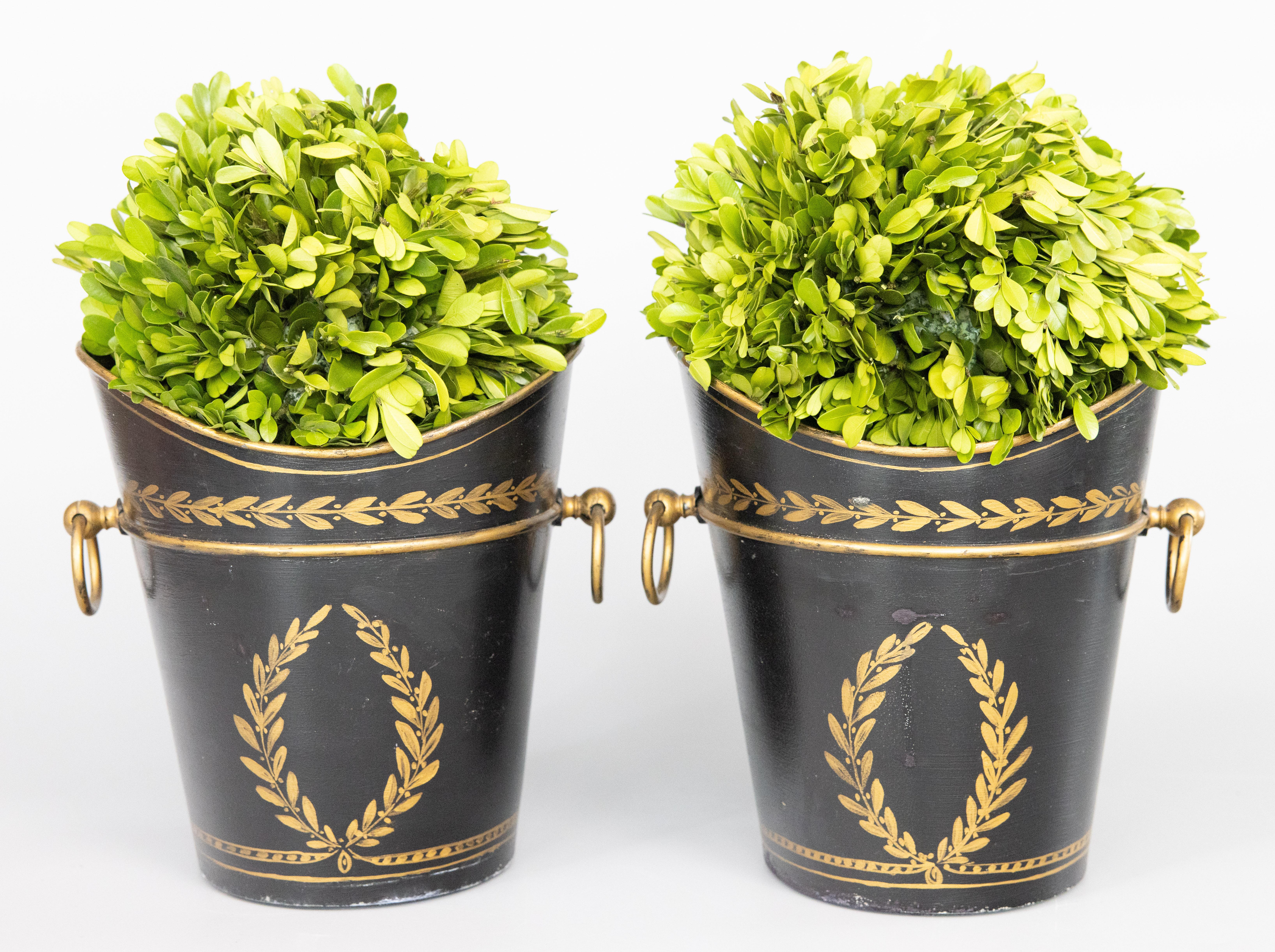 Une belle paire de jardinières ou cache-pots anciens en noir et or. Pas de marque de fabricant. Ces magnifiques jardinières sont ornées d'une guirlande de laurier finement peinte à la main et de poignées en anneau dorées. Ils seraient ravissants sur