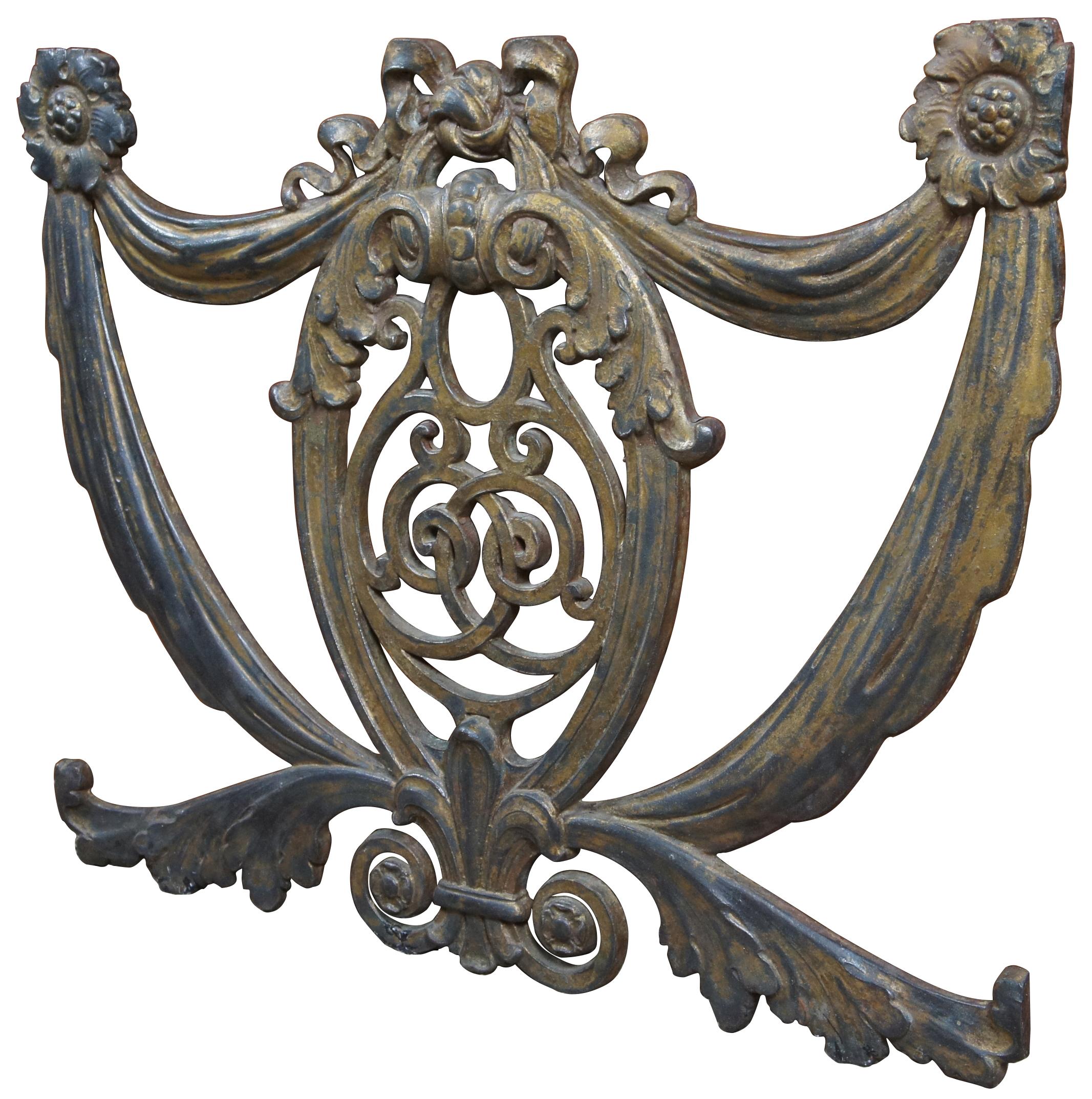 Antique reclaimed cast iron plaque featuring motifs of curtain swag and ribbons framing a scrolled shield with leaves and Fleur de Lis. Could be used as a wall medallion, embellishment or fireplace screen. Measures: 29”.
  