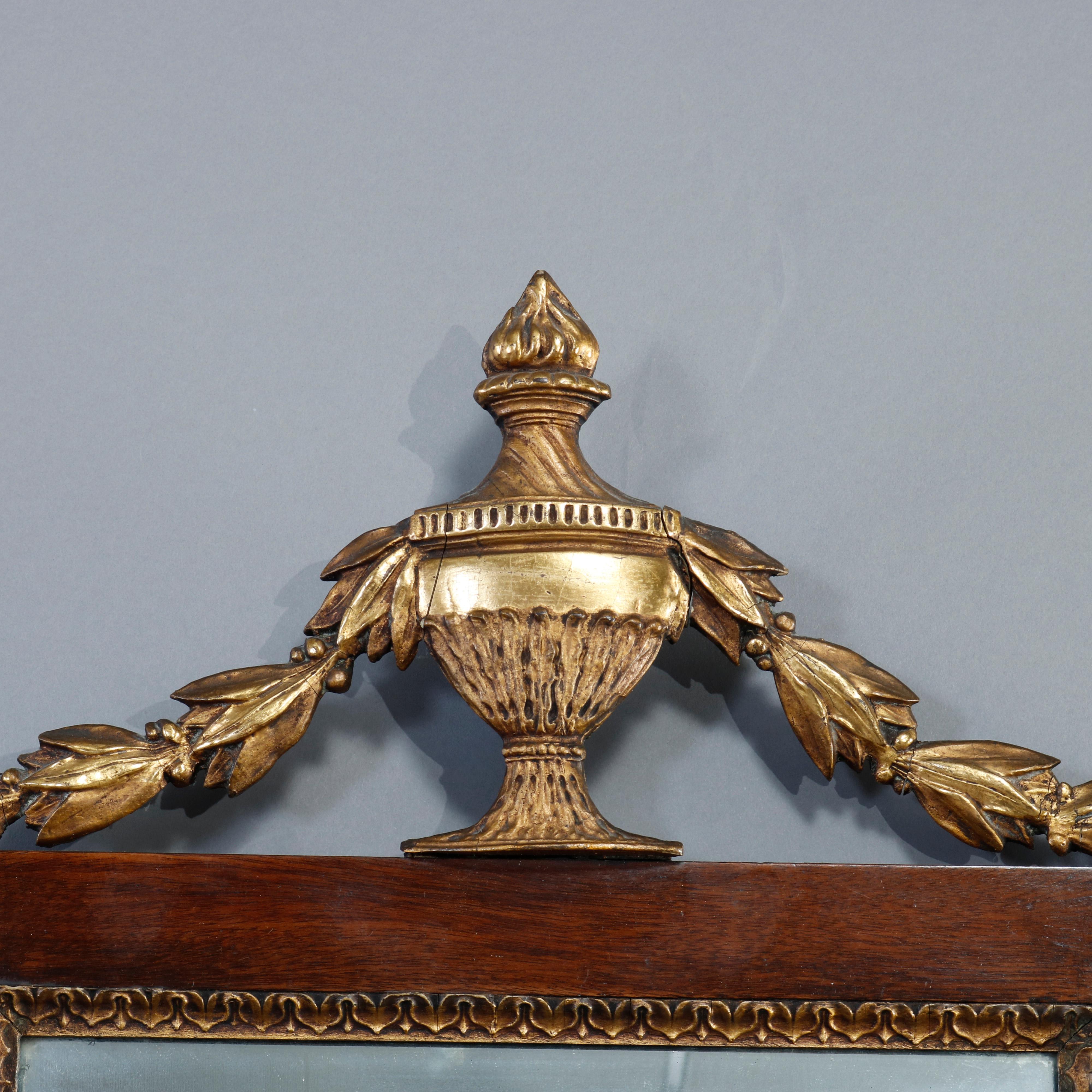 An antique French neoclassical wall mirror offers mahogany frame with giltwood urn-form finial having flanking inverted bellflower garland and trim, c1840

Measures: 27.5