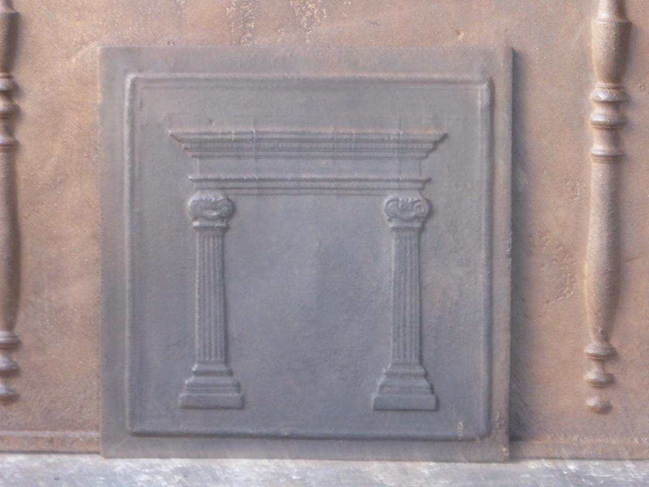 19th century French neoclassical fireback with two pillars of a temple. The pillars symbolize liberty, one of the three values of the French revolution. The fireback is made of cast iron. It has a natural brown patina, which can be made black upon