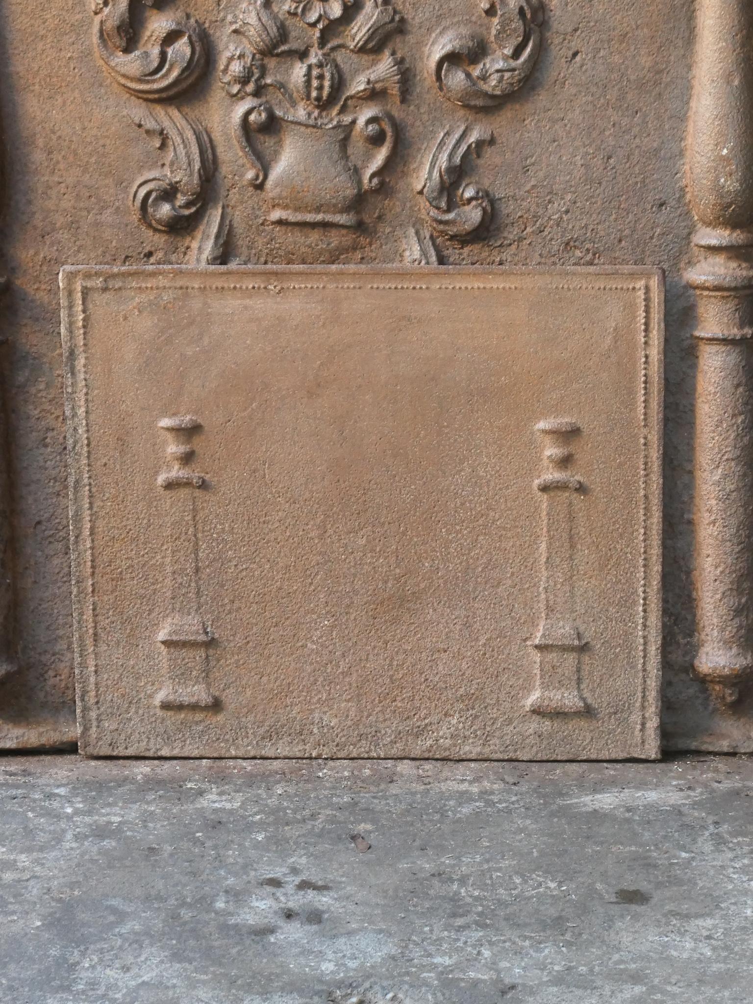 18th - 19th Century French neoclassical fireback with two pillars of freedom. The pillars symbolize the value liberty, one of the three values of the French revolution. 

The fireback is made of cast iron and has a brown patina. Upon request it