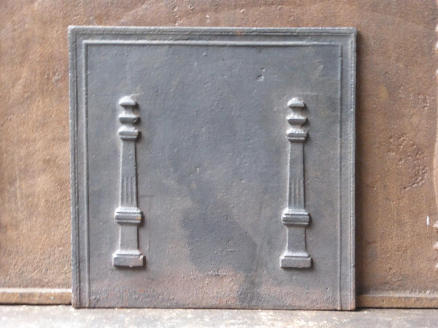 19th century French neoclassical fireback with two pillars of freedom. The pillars symbolize the value liberty, one of the three values of the French revolution. 

The fireback is made of cast iron and has a natural black / pewter patina. It is in