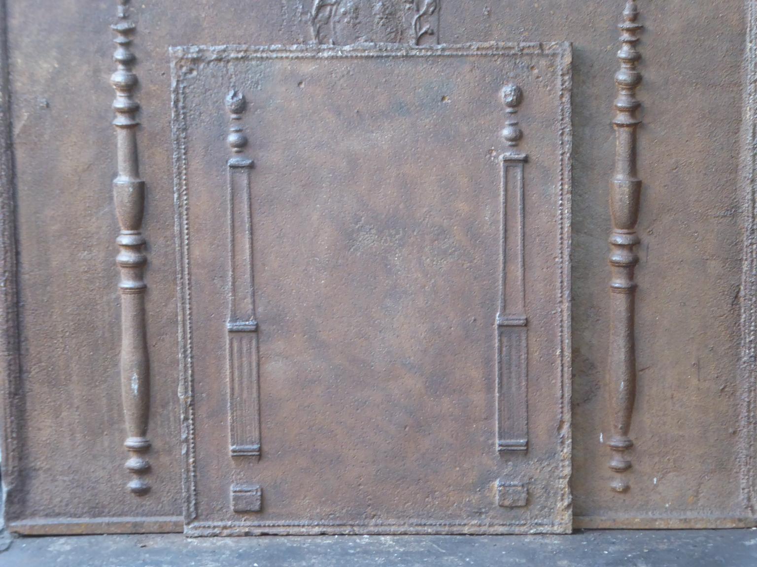 19th century French neoclassical fireback with two pillars of freedom. The pillars symbolize the value liberty, one of the three values of the French revolution. 

The fireback is made of cast iron and has a natural brown patina. Upon request it