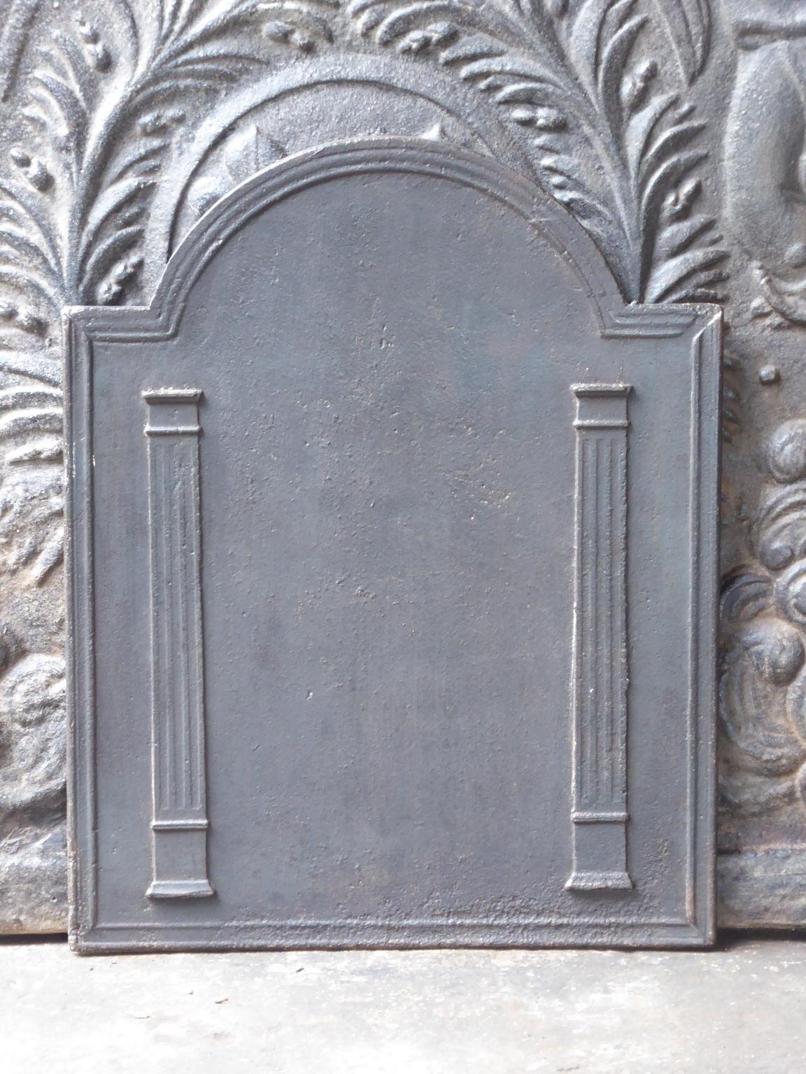 Plaque de cheminée néoclassique française du XIXe siècle avec deux piliers de la liberté. Les piliers symbolisent la valeur liberté, l'une des trois valeurs de la Révolution française. 

La plaque de cheminée est en fonte et a une patine brune