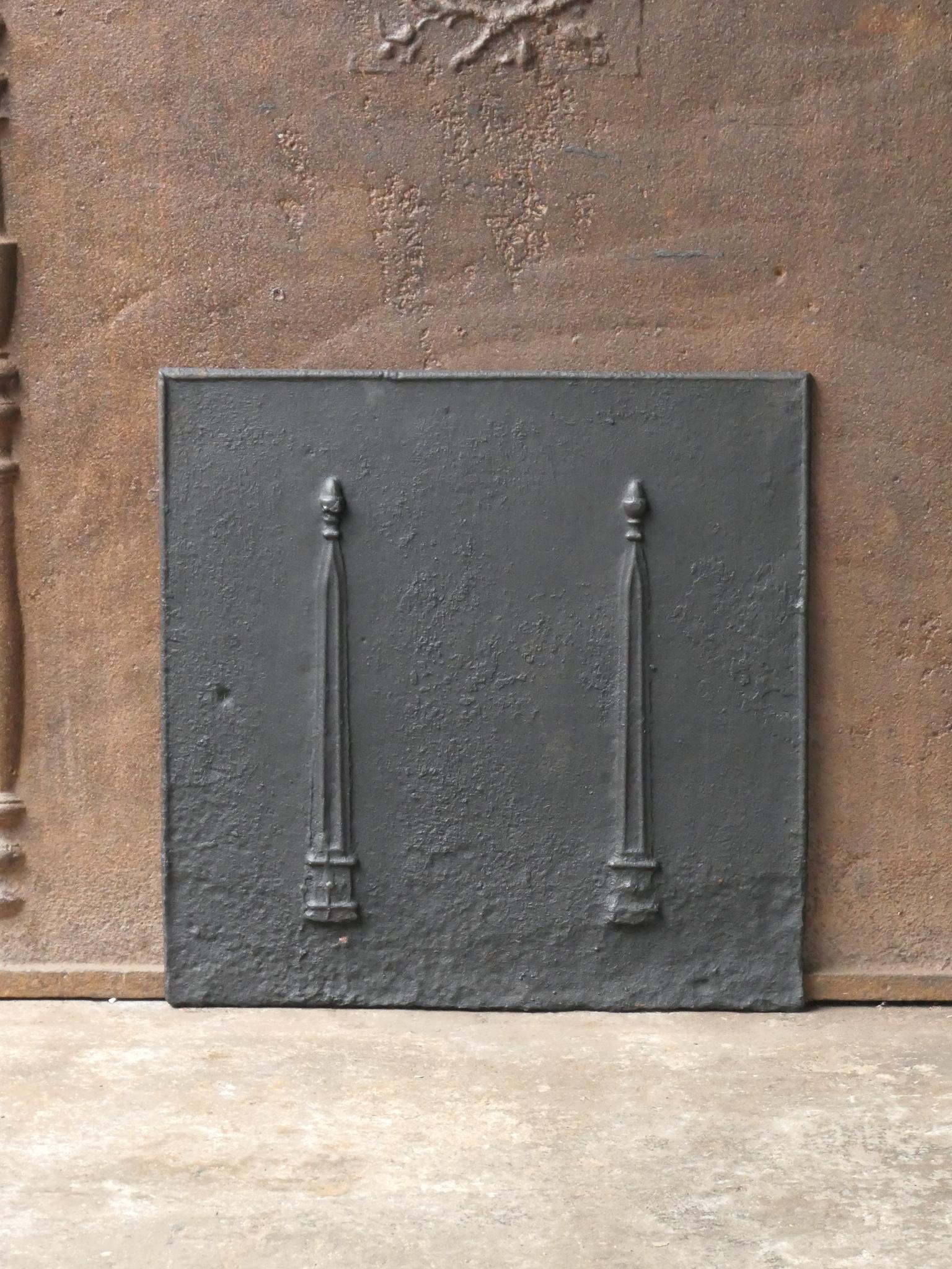 19th century French neoclassical fireback with two pillars of freedom. The pillars symbolize liberty, one of the three values of the French revolution. 

The fireback is made of cast iron and has a black / pewter patina. The fireback is in a good