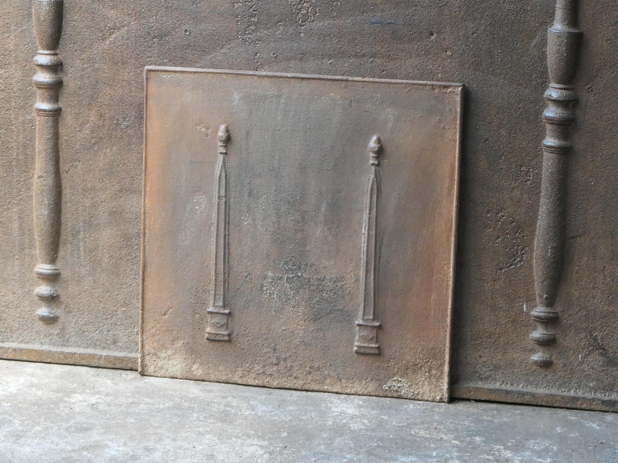 19th century French neoclassical fireback with two pillars of freedom. The pillars symbolize the value liberty, one of the three values of the French revolution. 

The fireback is made of cast iron and has a natural brown patina. Upon request it can