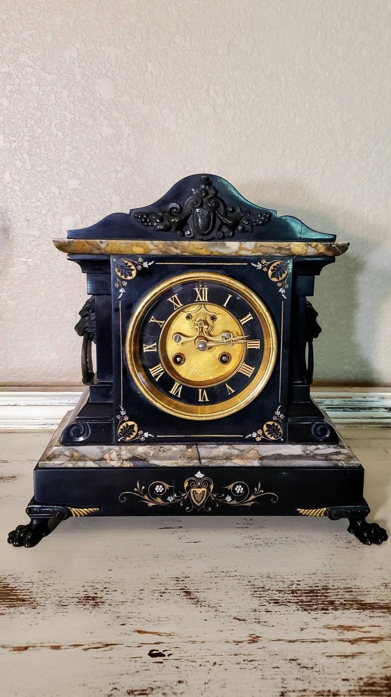 A magnificent turn of the late 19th / early 20th century French three piece mantel set, retailed by the renowned Bailey Banks and Biddle, with movement by Samuel Marti of Paris.

The stunning antique clock, circa 1900, features a shaped