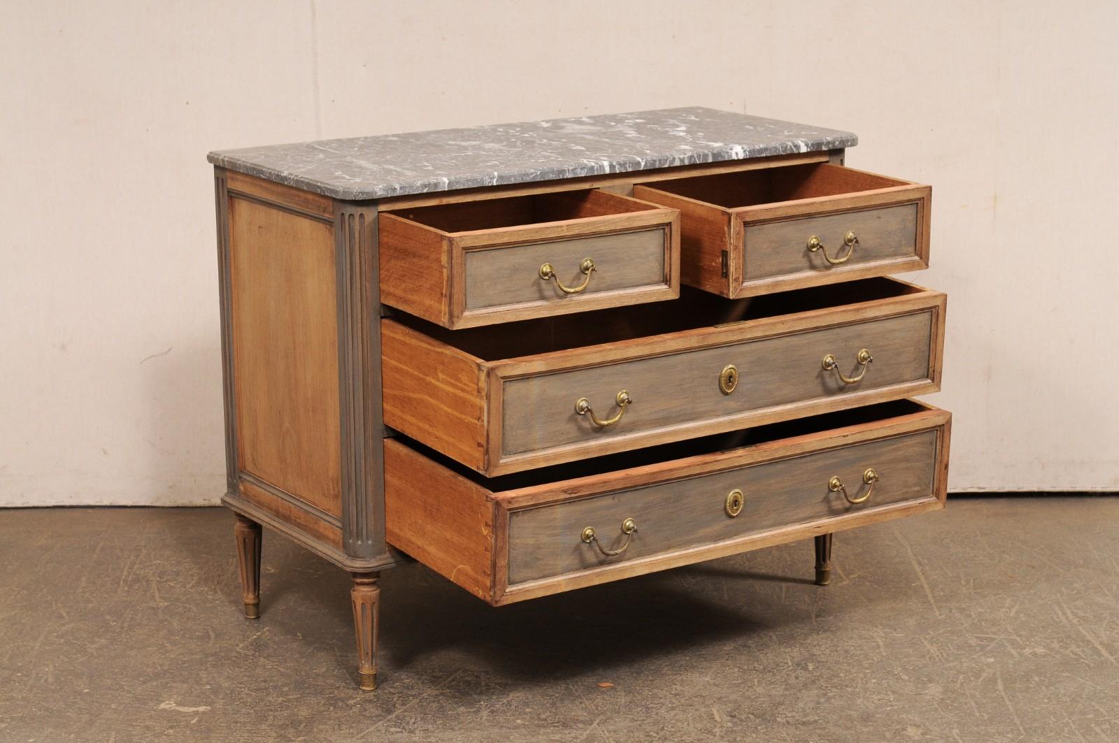 Una cassapanca in stile neoclassico francese, con piano in marmo e ferramenta originali, risalente agli inizi del XX secolo. Questa cassapanca antica proveniente dalla Francia presenta un piano in marmo grigio di forma rettangolare con angoli