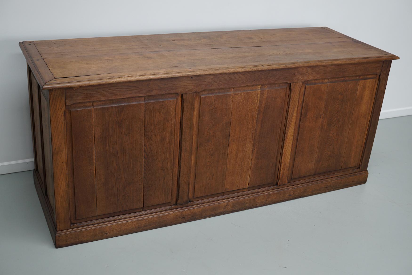 Este mueble boticario se fabricó a principios del siglo XX en Francia con madera de roble. Dispone de 9 cajones grandes con tiradores de latón. Las dimensiones interiores de los cajones son DWH 45 x 55 x 18 cm. También es muy adecuado como mostrador