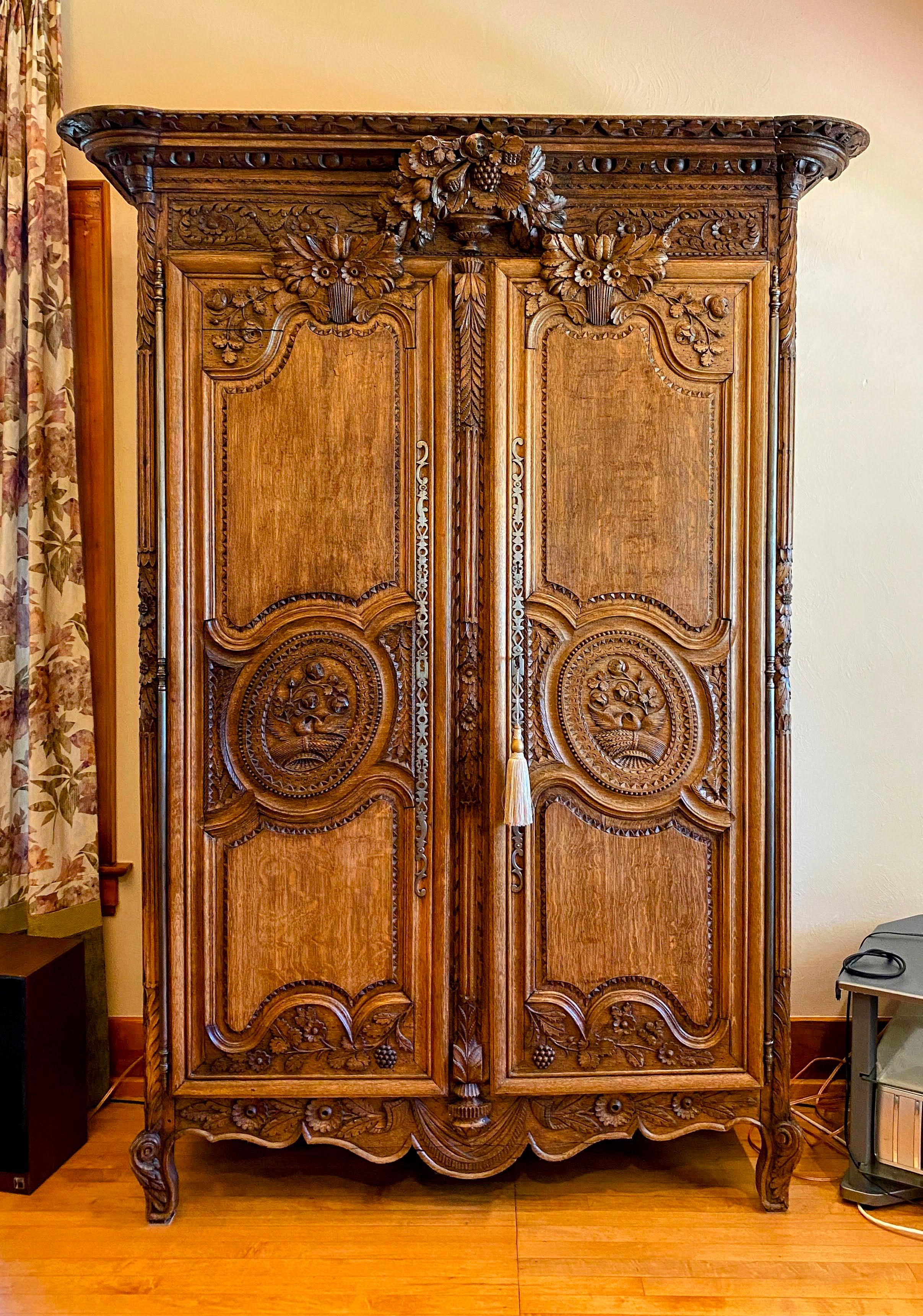 Exquisite Norman style de Bayeux, Oak, circa late 1800's. This armoire is heavily and ornately carved throughout, 2 doors, 3 interior shelves & two drawers one locking, inside.  Peg construction.  Newer addition of 6 interior drawers added without